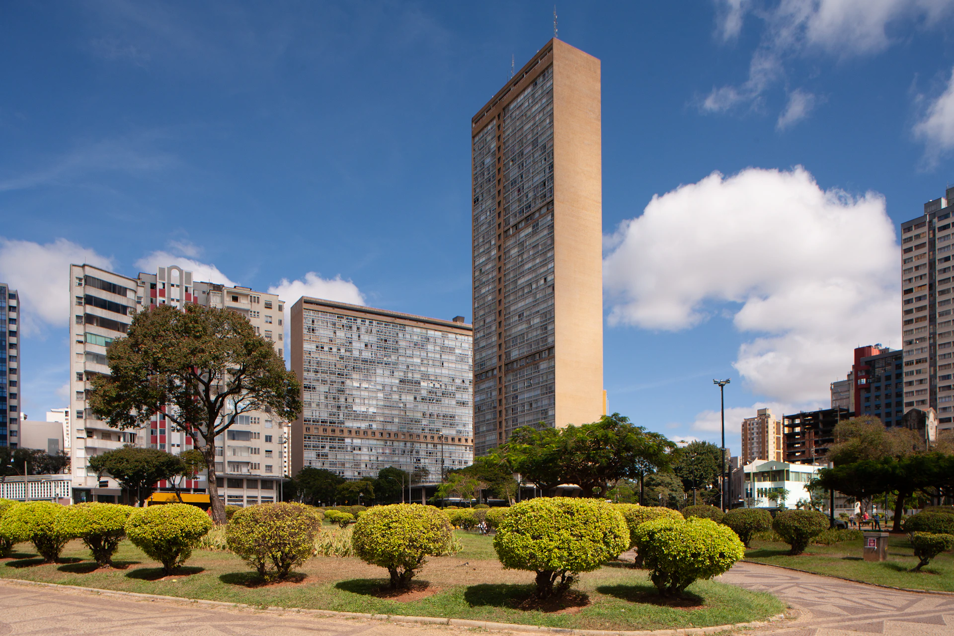Modern buildings and manicured park under a blue sky