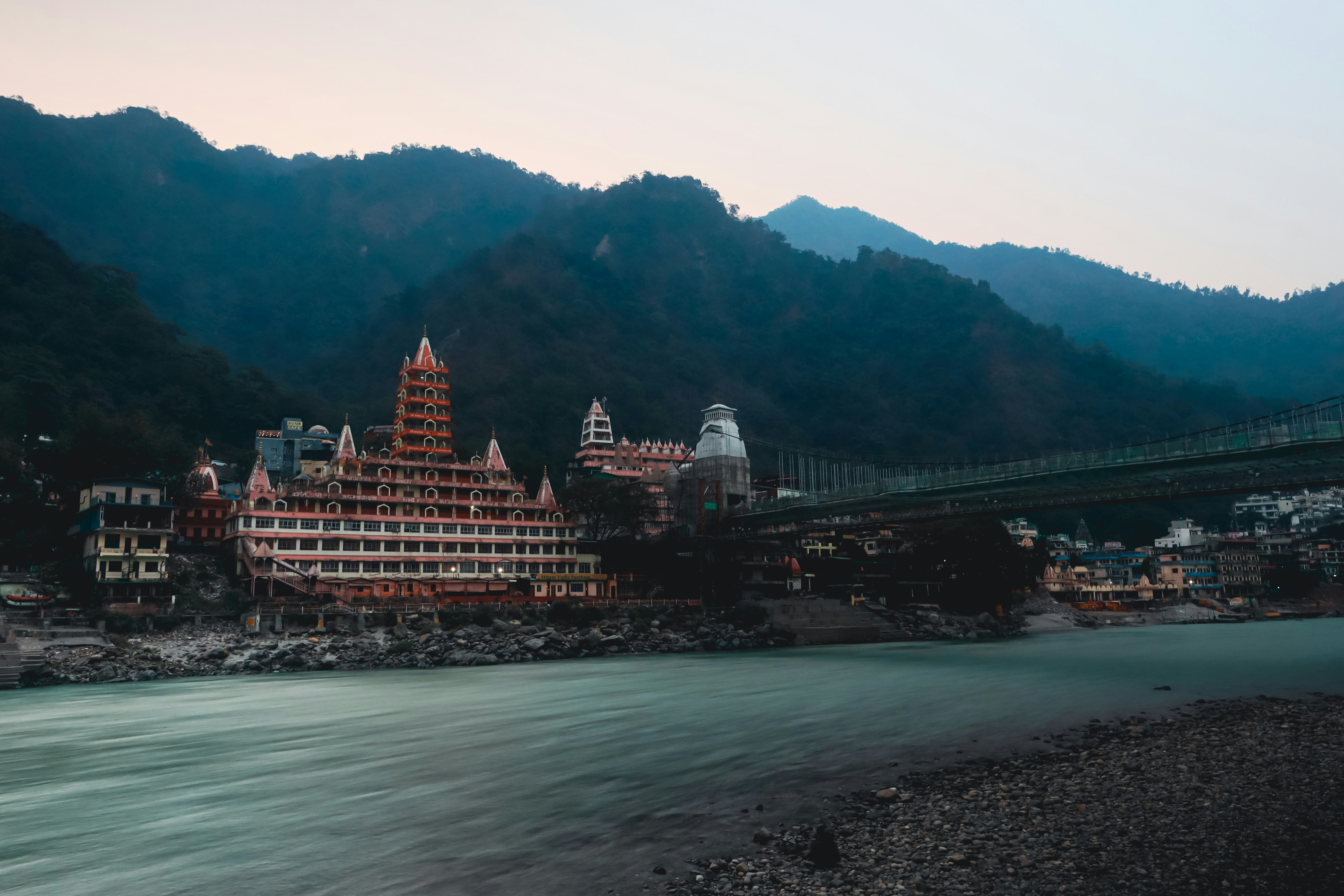 River flowing past buildings near mountains at dusk