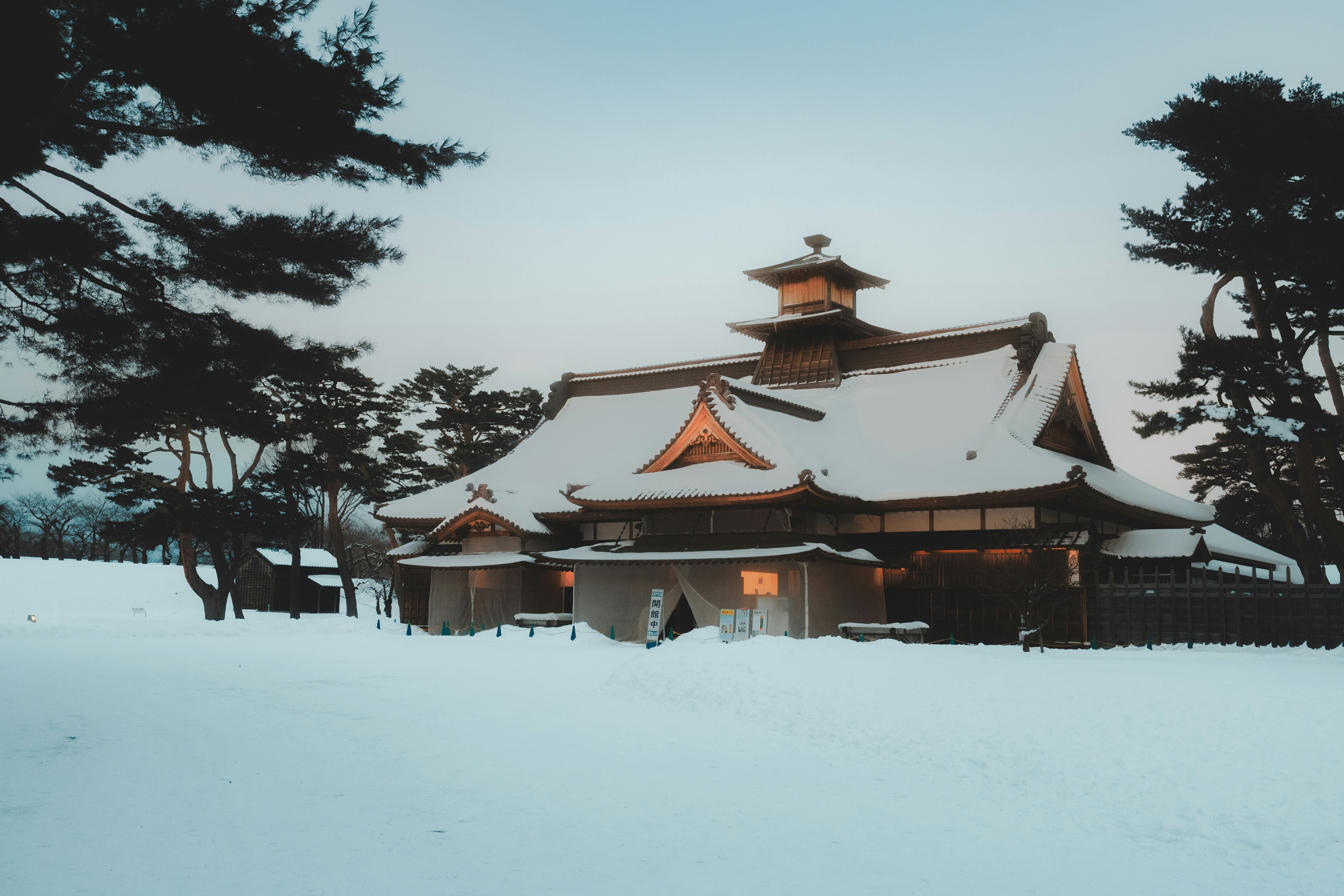 Snow-covered traditional japanese building at dusk