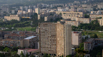 Cityscape with apartment buildings and a tall concrete structure.