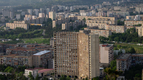 Cityscape with apartment buildings and a tall concrete structure.