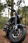 A black motorcycle parked on a forest path.