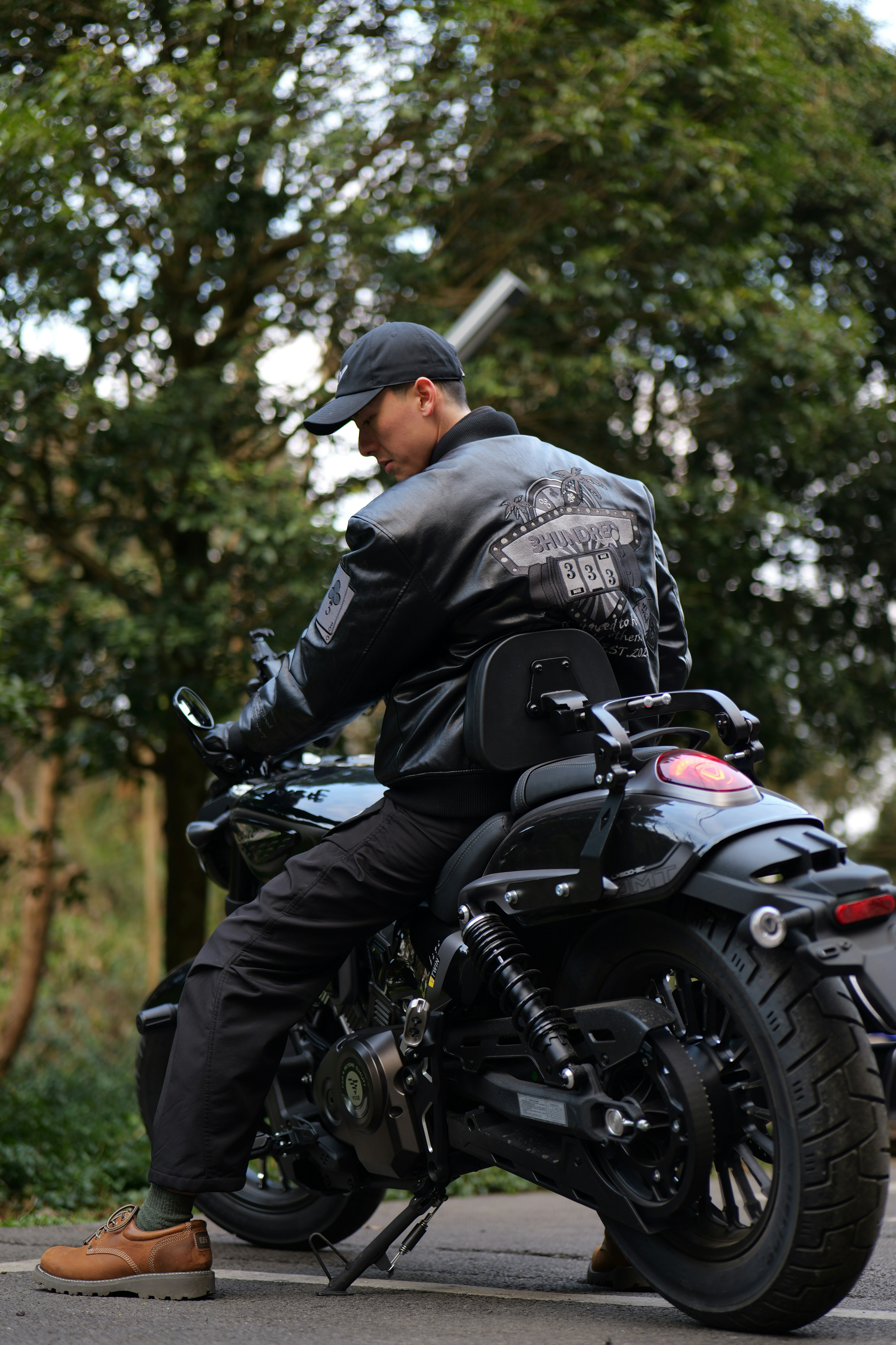 Man in leather jacket on a black motorcycle