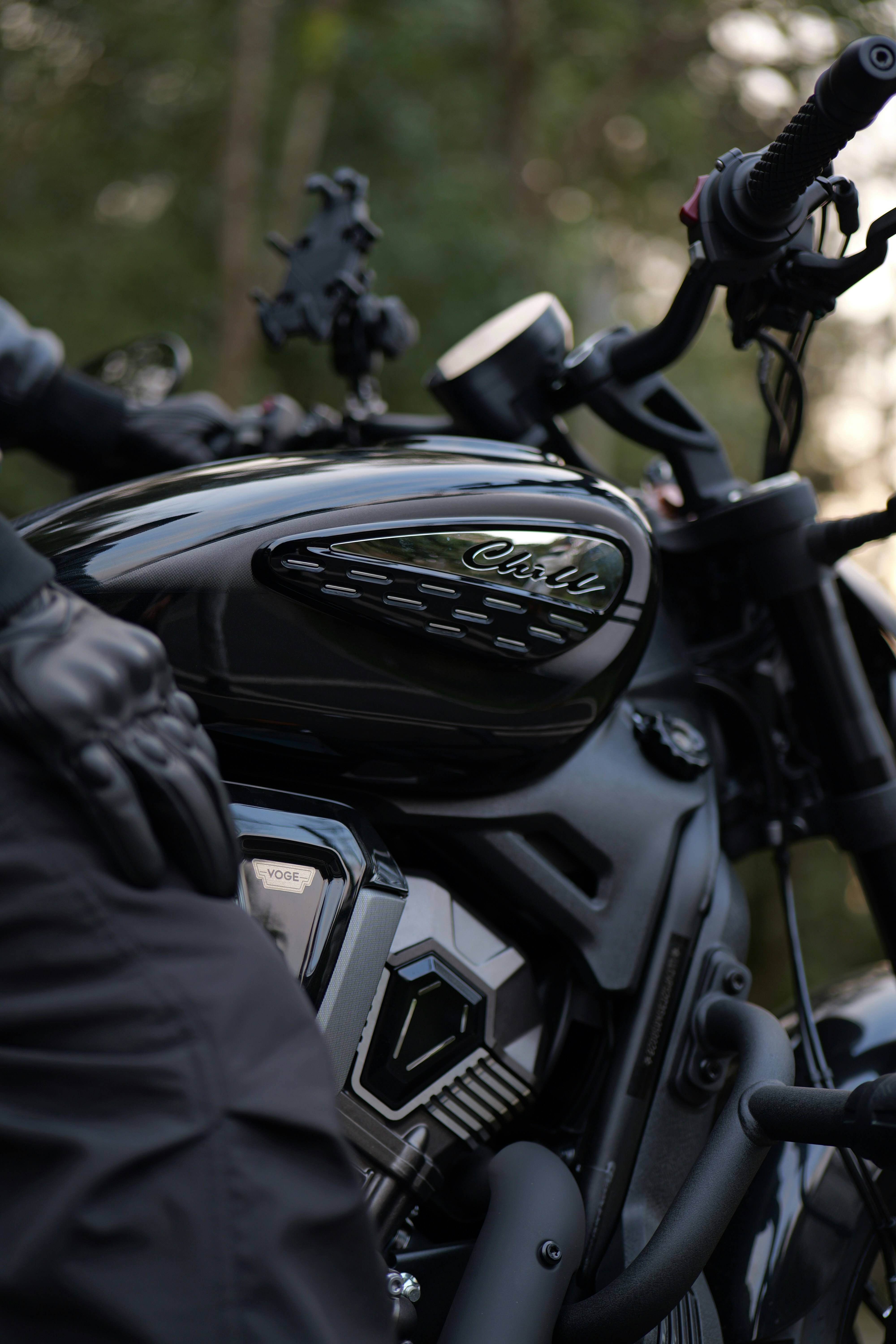 A black motorcycle with a person's hand on it