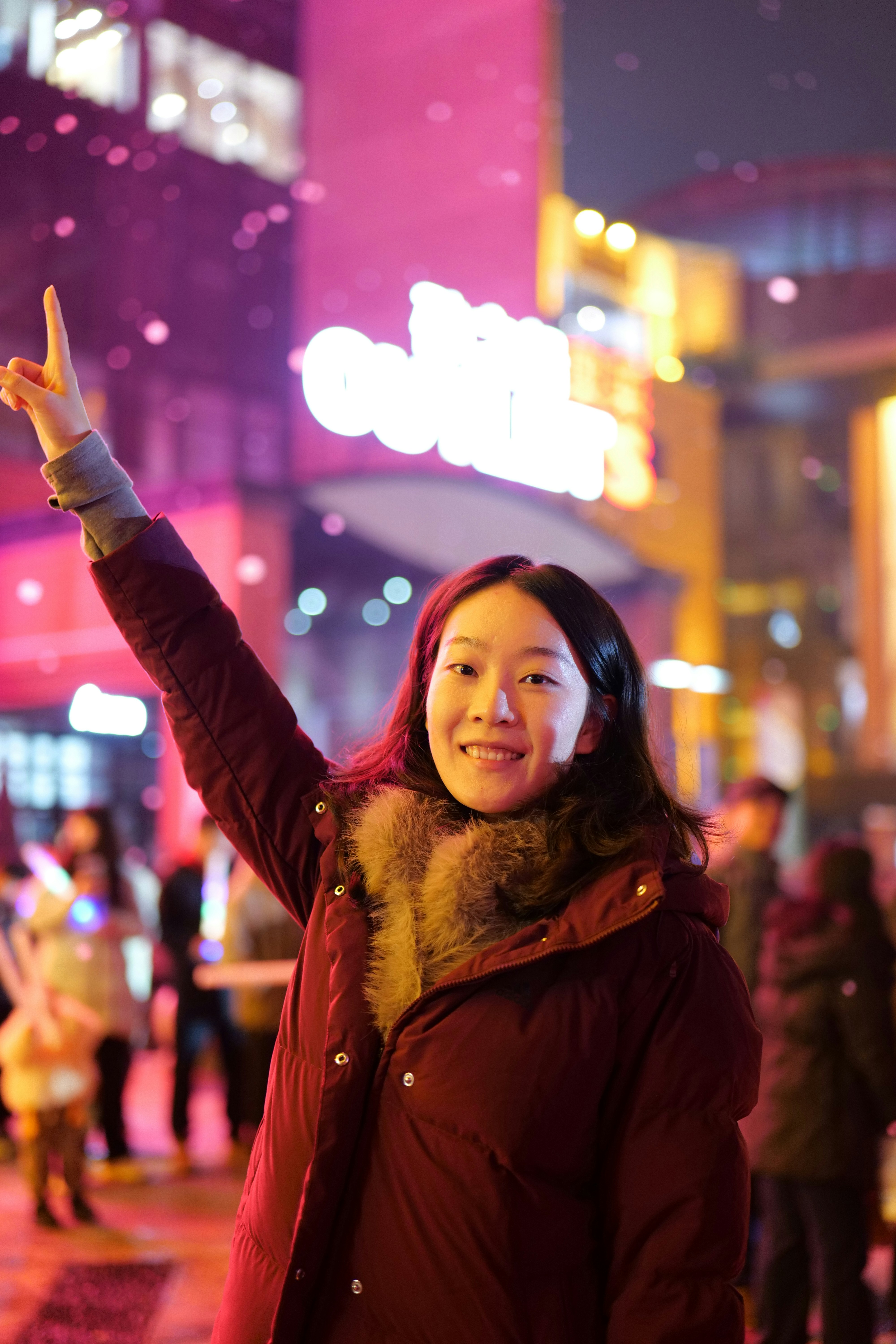 Young woman with arm raised at night