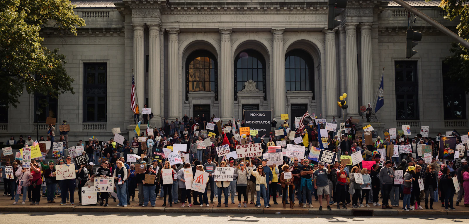 Young protesters holding signs on the steps of a building