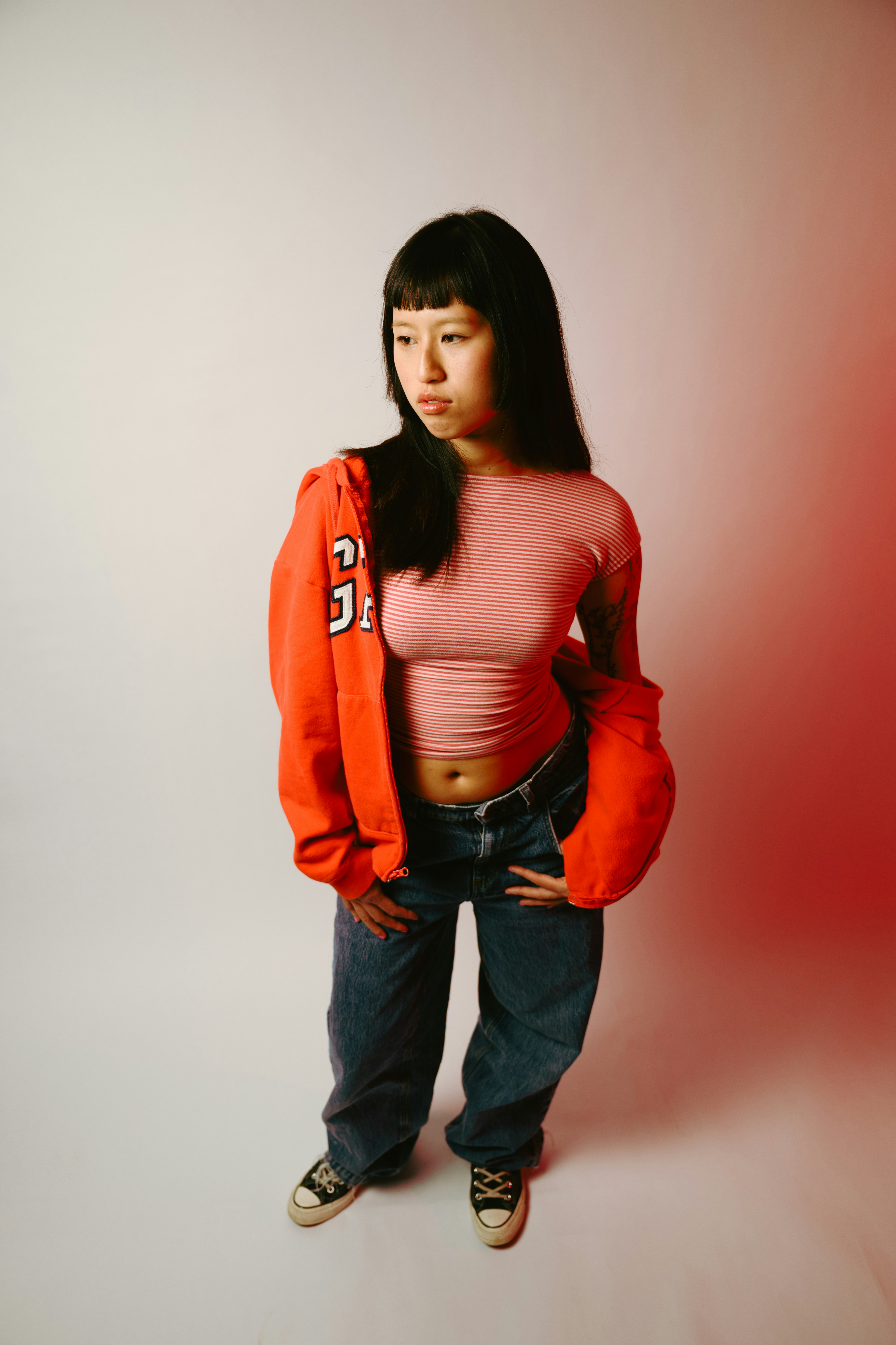 Young woman in casual clothing posing against a white background.