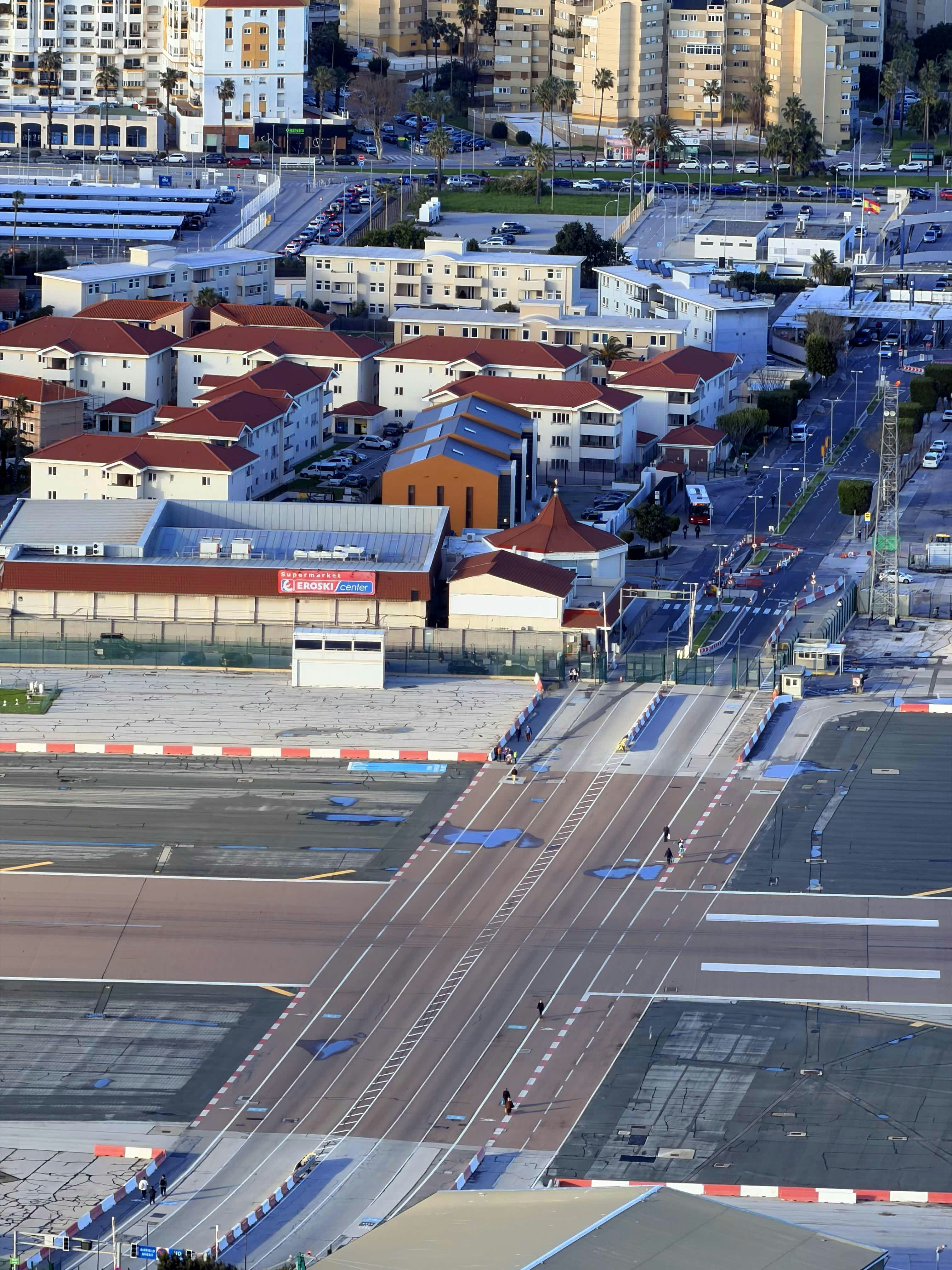 An aerial view of gibraltar airport runway crossing a road.