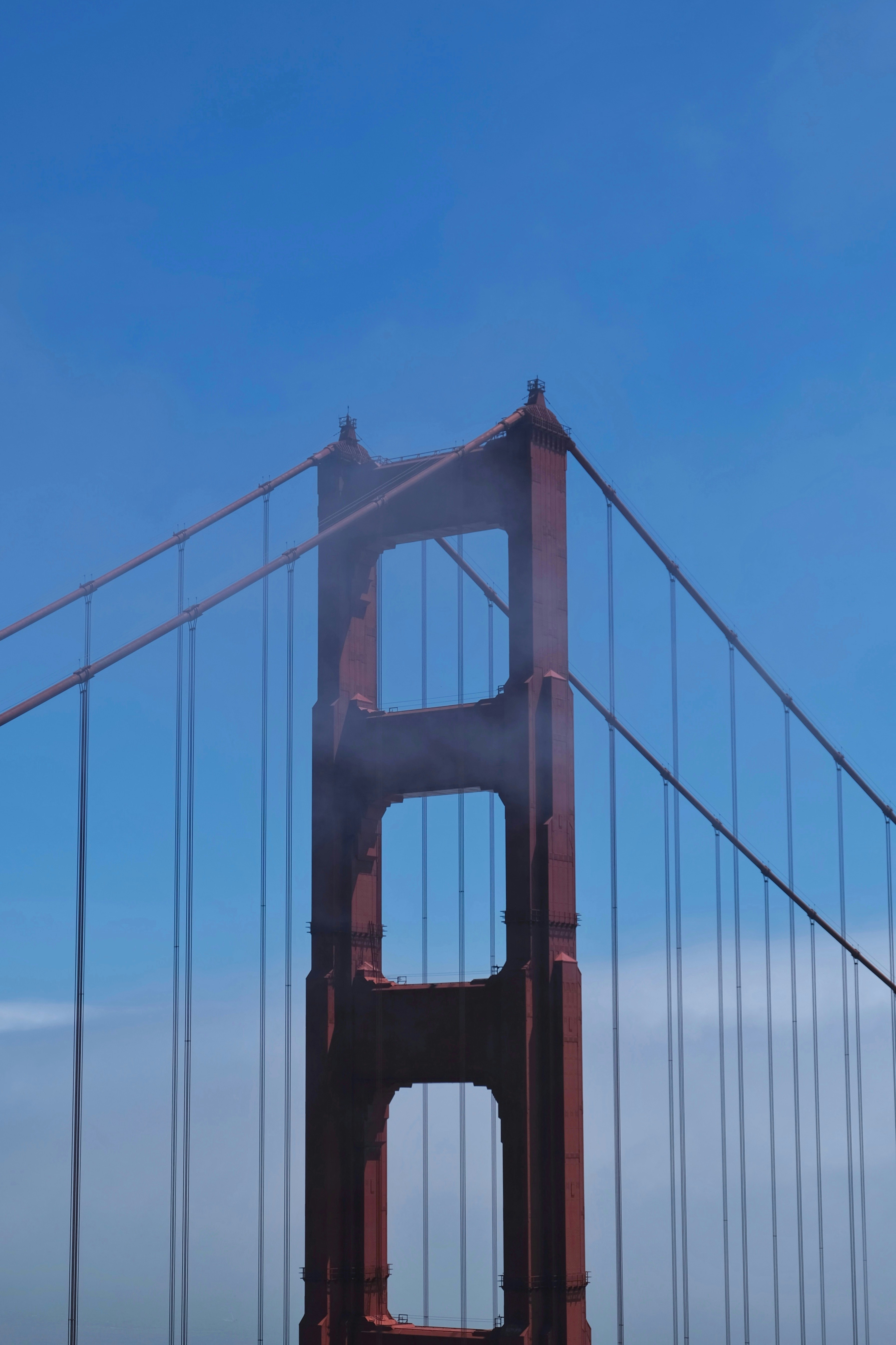 Golden gate bridge tower against a clear blue sky