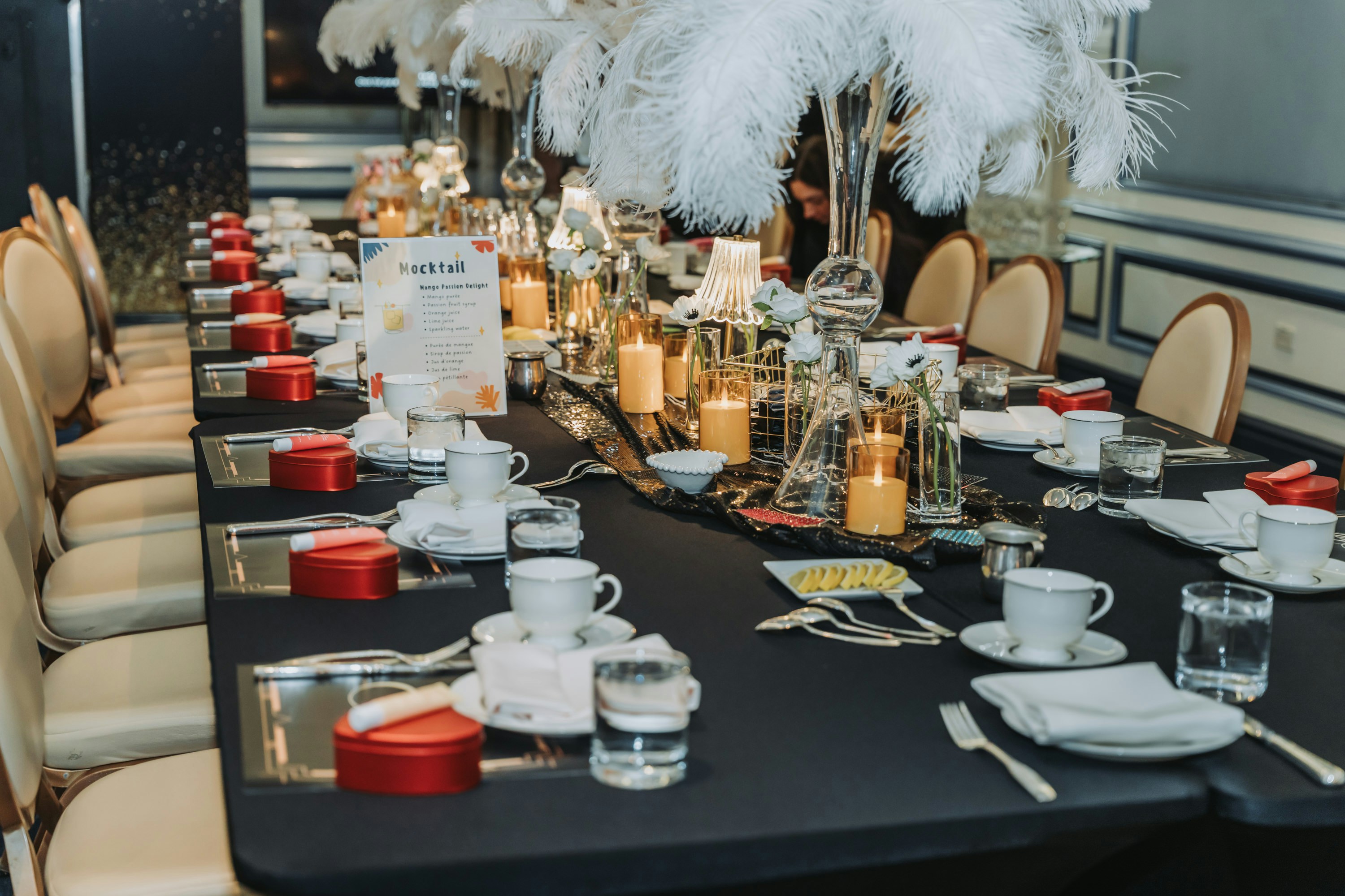 Elegant banquet table setting with white feathers and candles