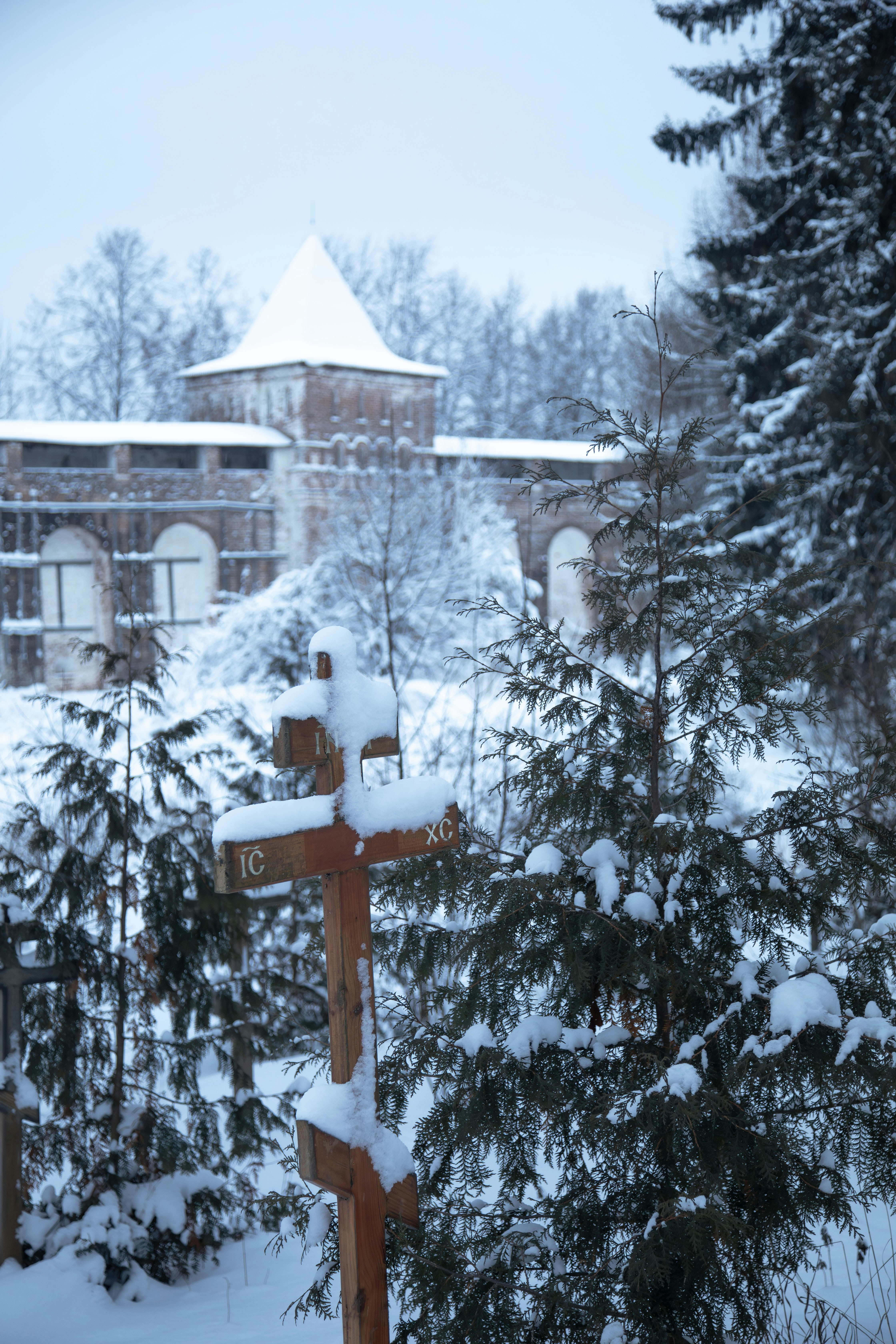Wooden crosses covered in snow near an old fortress