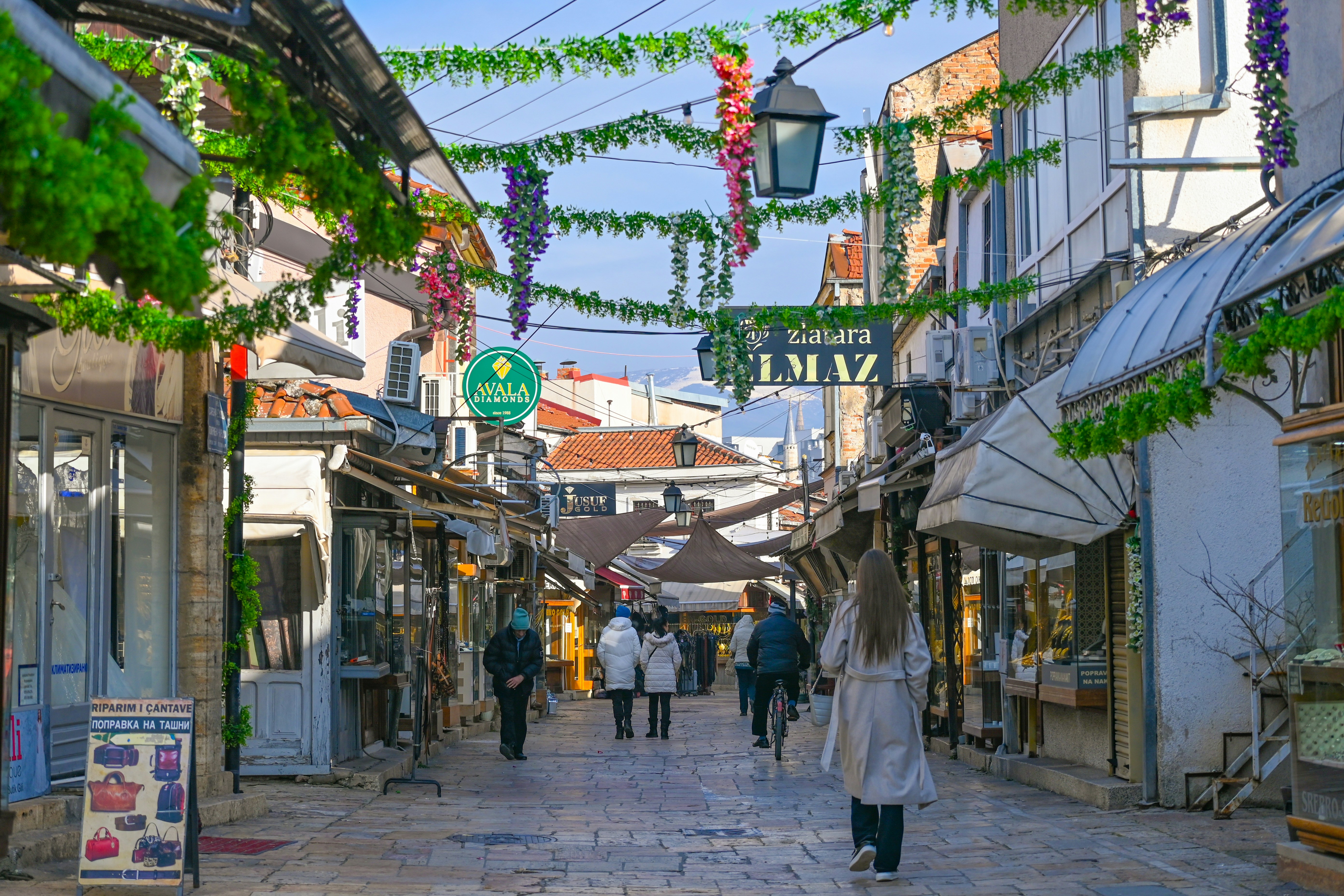 People walking down a charming street lined with shops.