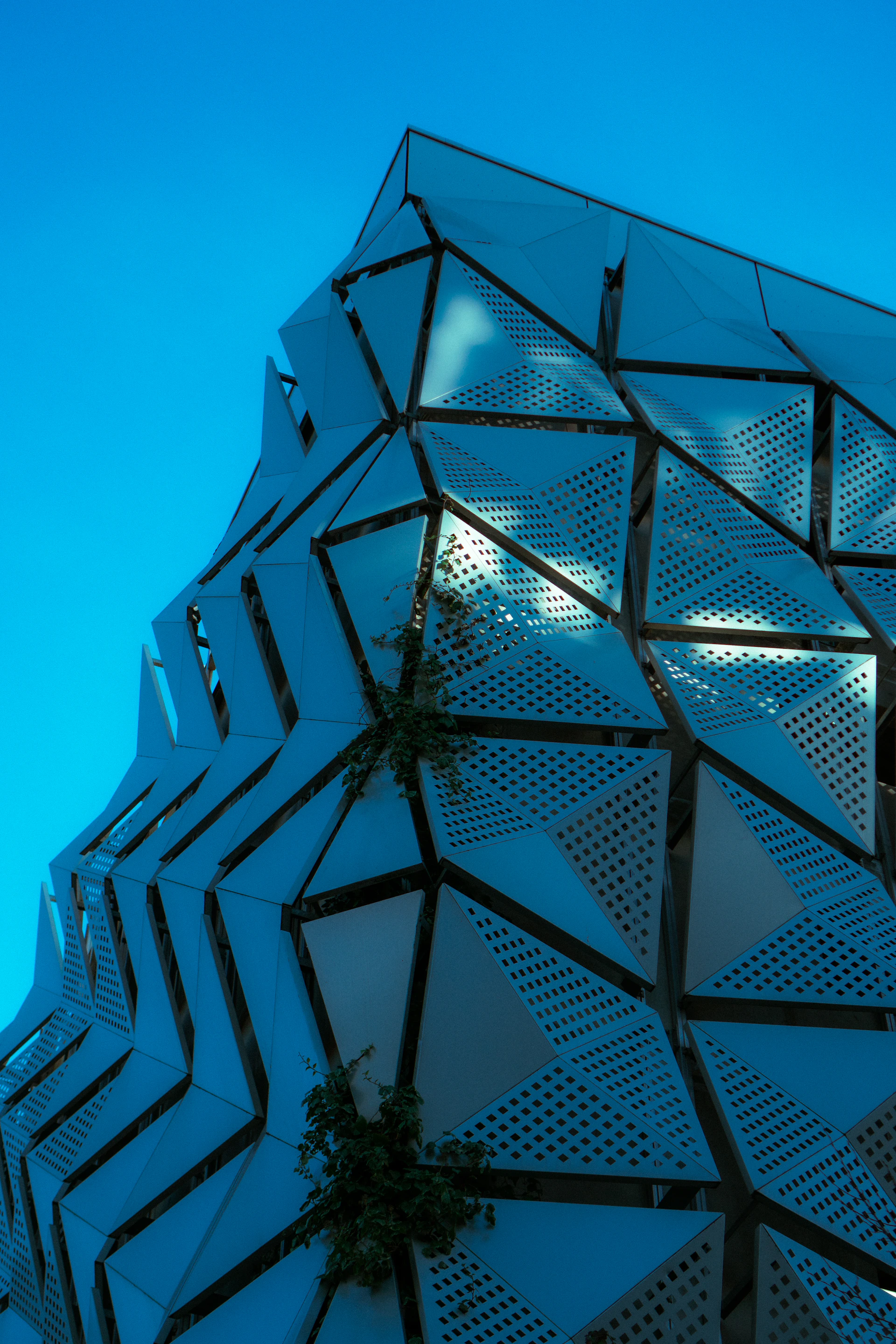 Modern building facade with geometric patterns against blue sky