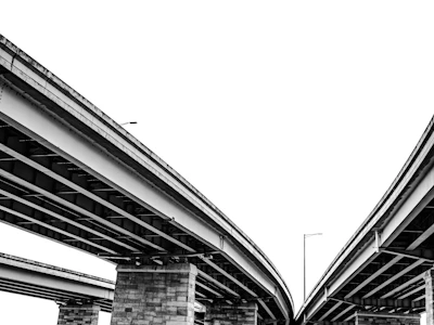 Overhead view of highway overpasses against a white sky.