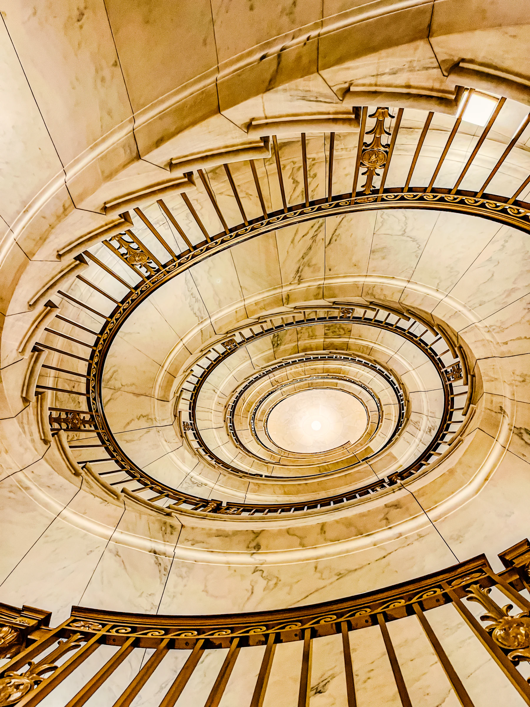 Escadaria de mármore com guarda-corpo detalhado, em composição simétrica