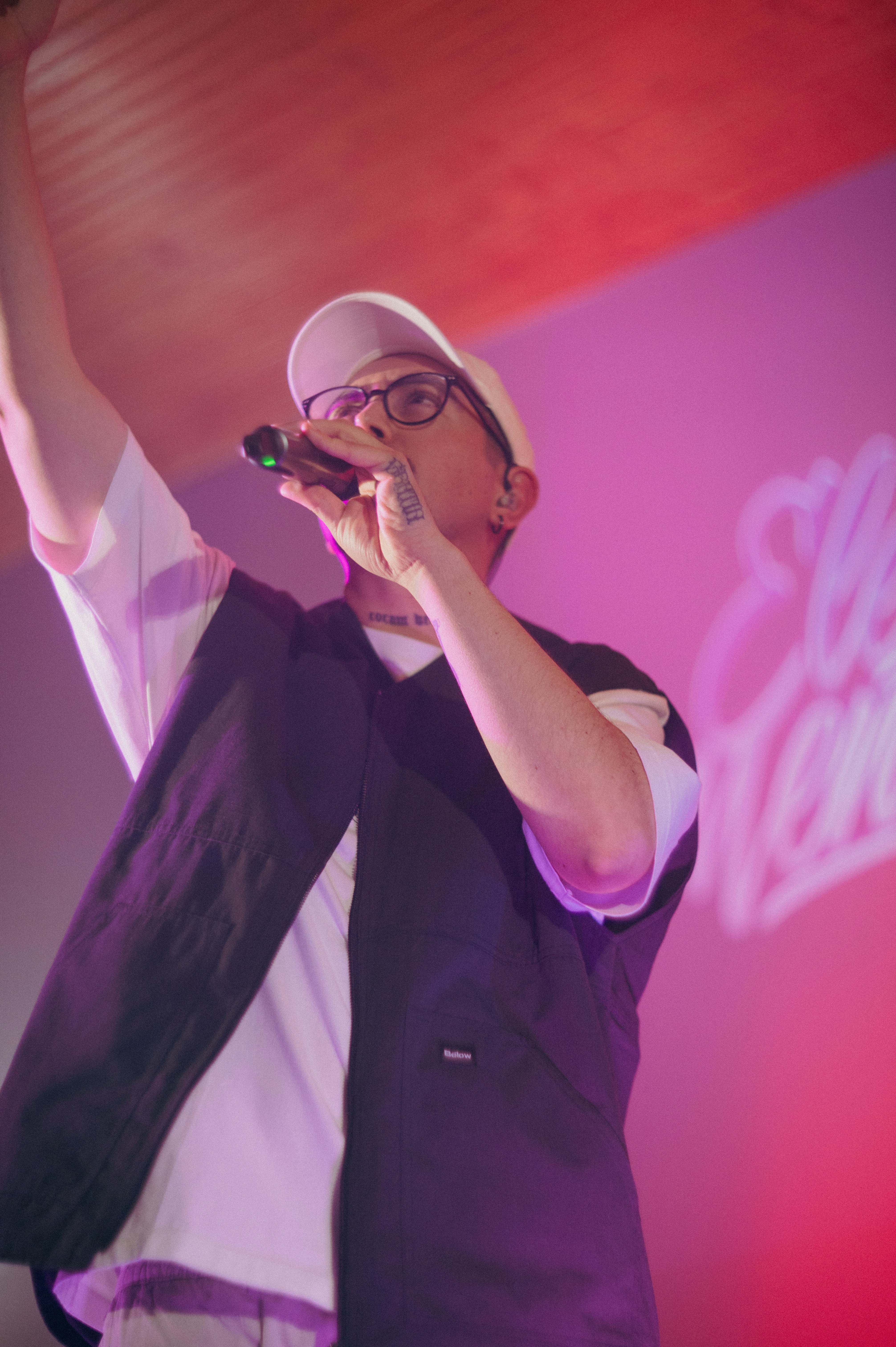 A rapper performs on stage with a microphone.