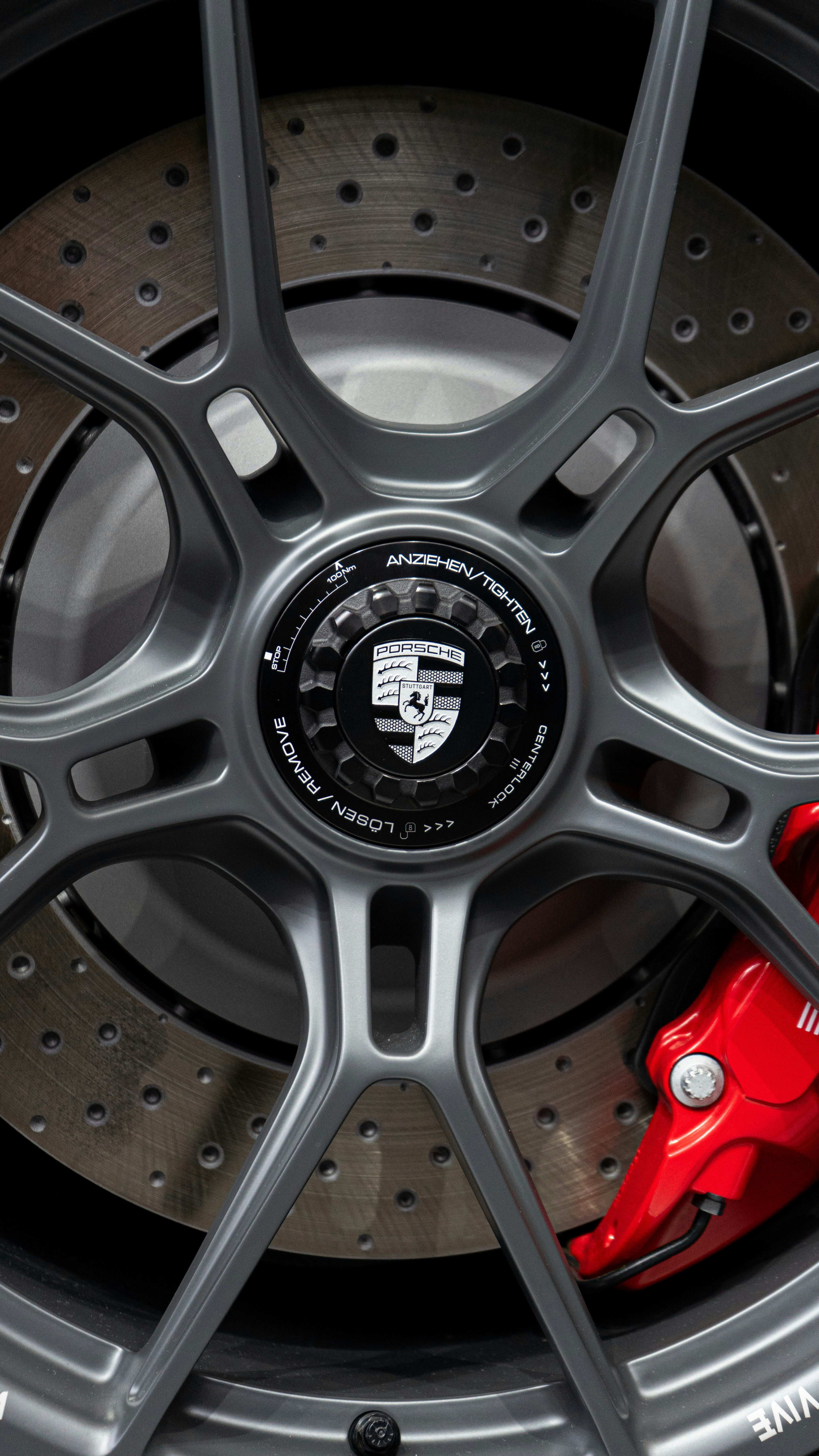 Close-up of a grey porsche wheel with red brake caliper.