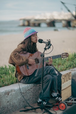 Woman playing guitar and singing by the sea