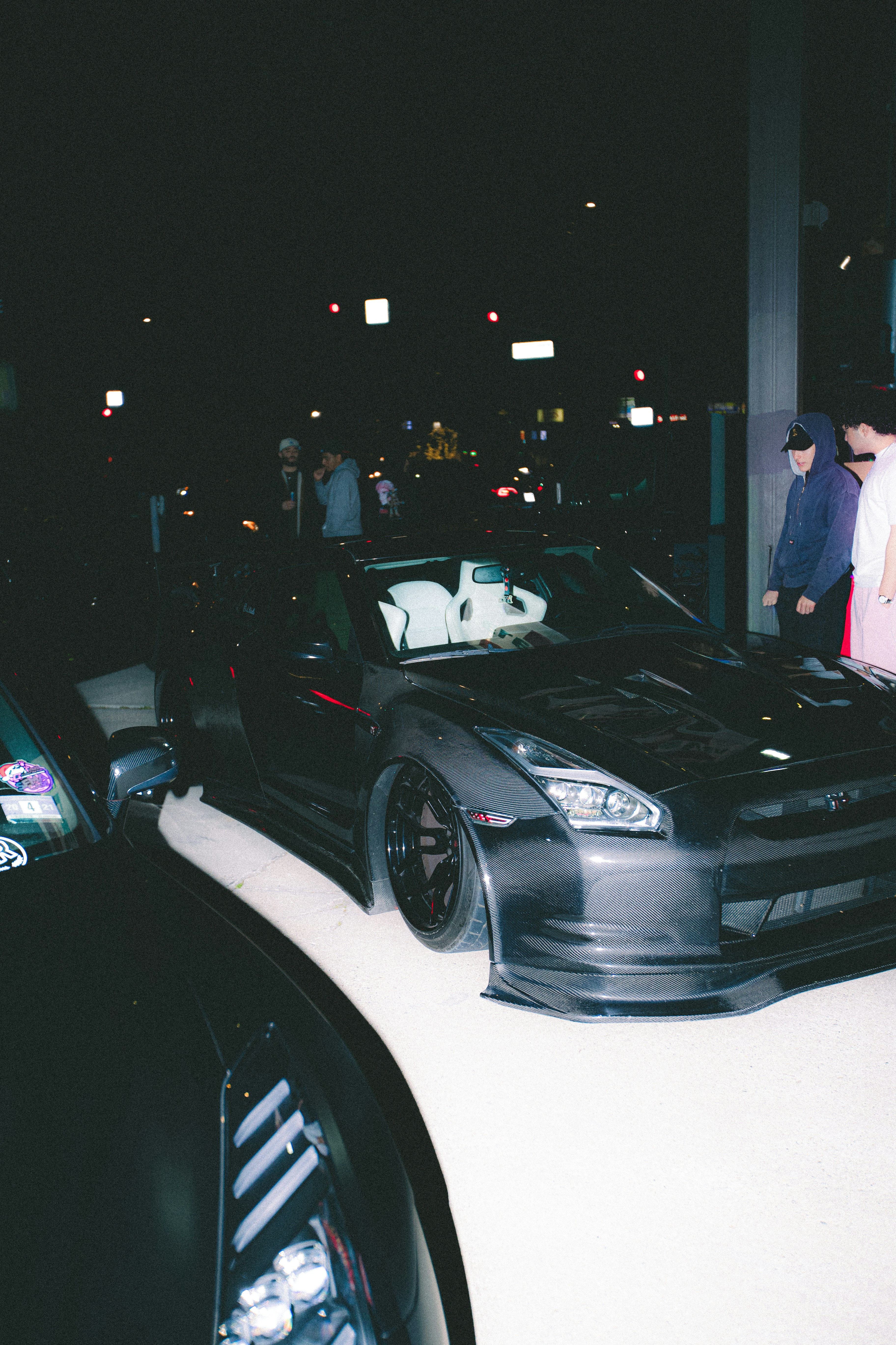 Two dark sports cars parked at night