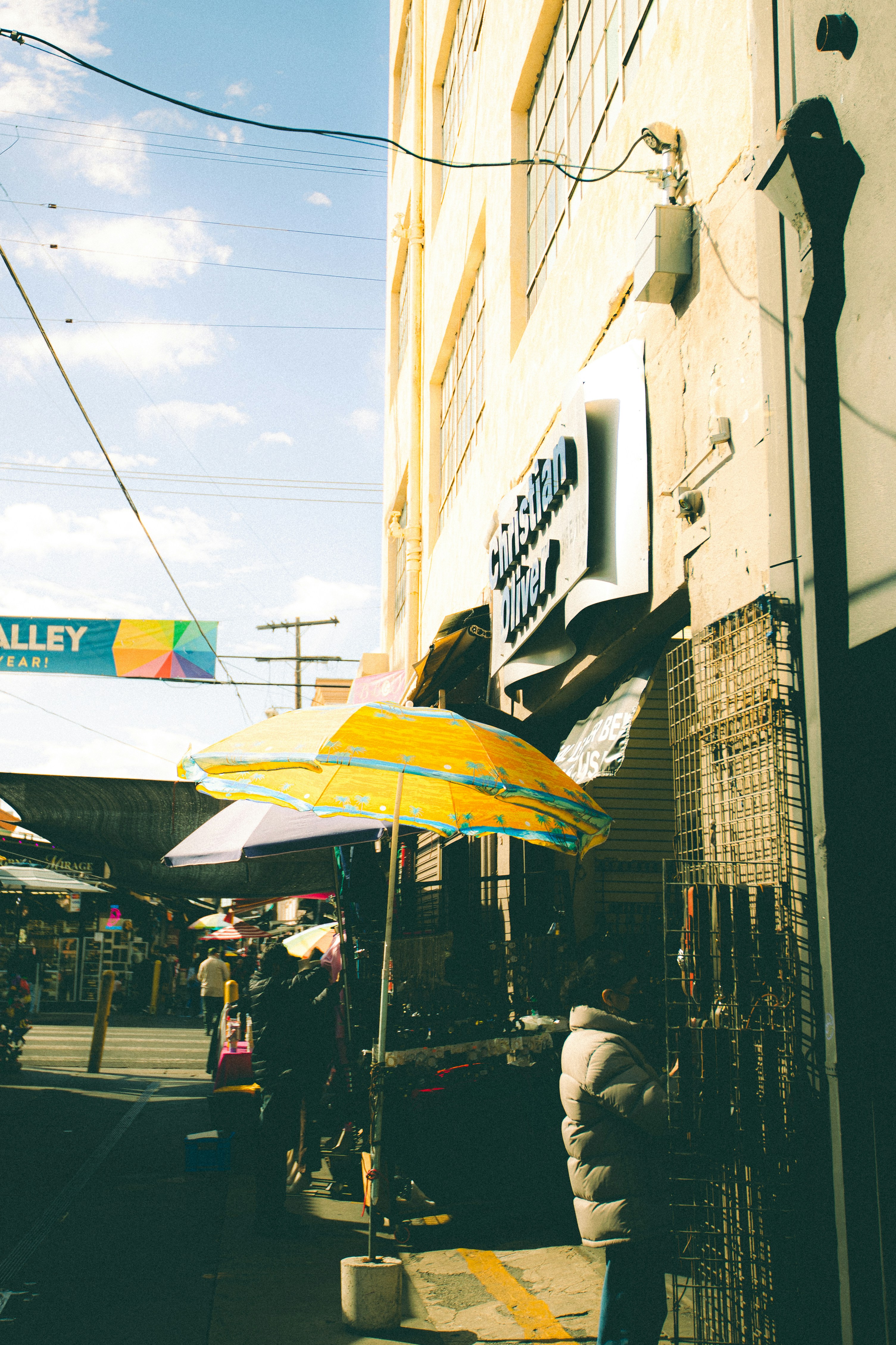 Street market with yellow umbrella and building