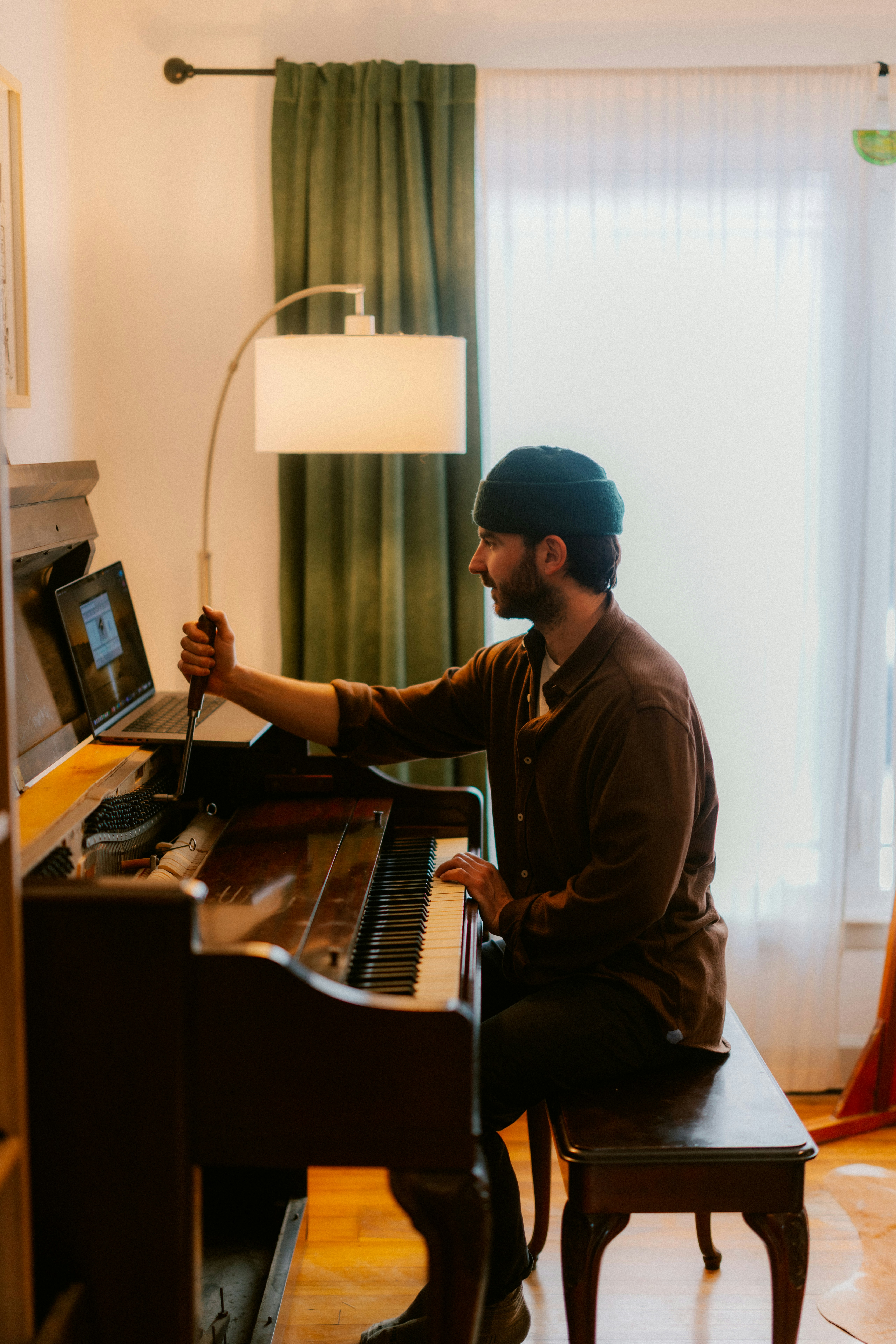 Man playing piano with laptop open