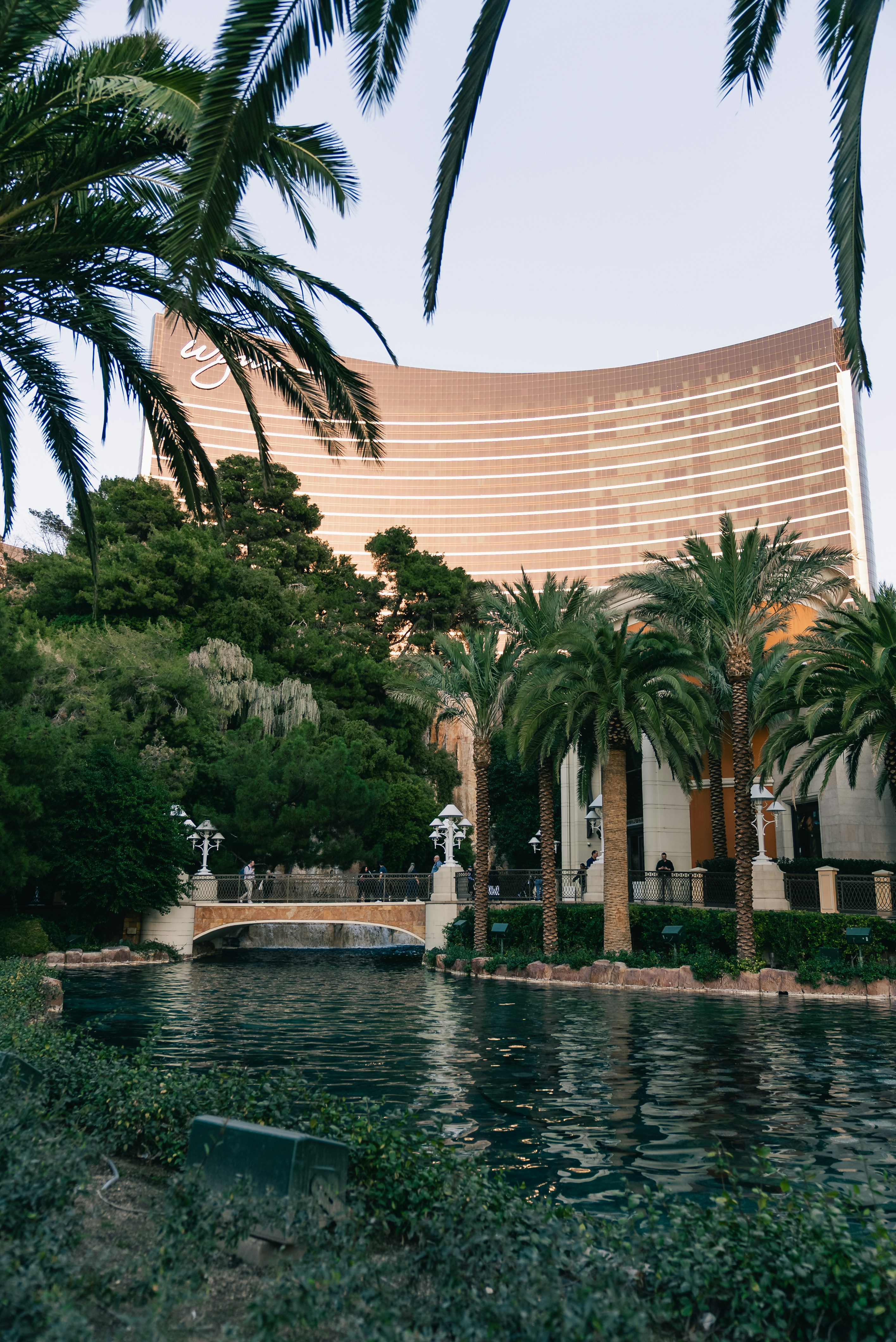 Large hotel building with palm trees and water