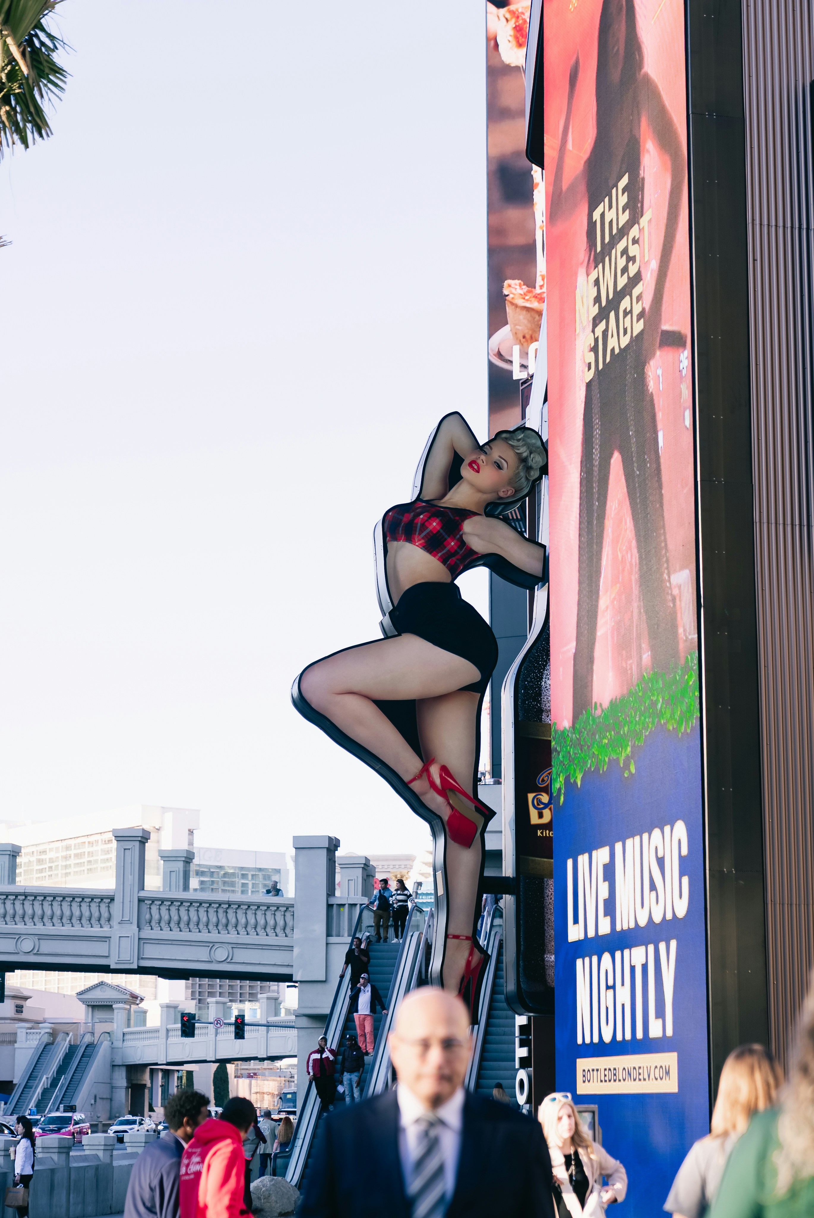 Woman posing on a building facade with advertisements.