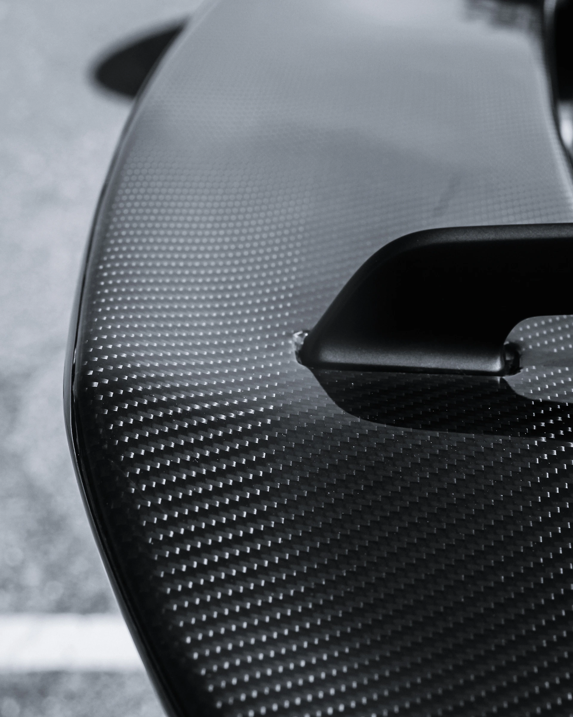 Close-up of a black carbon fiber car spoiler