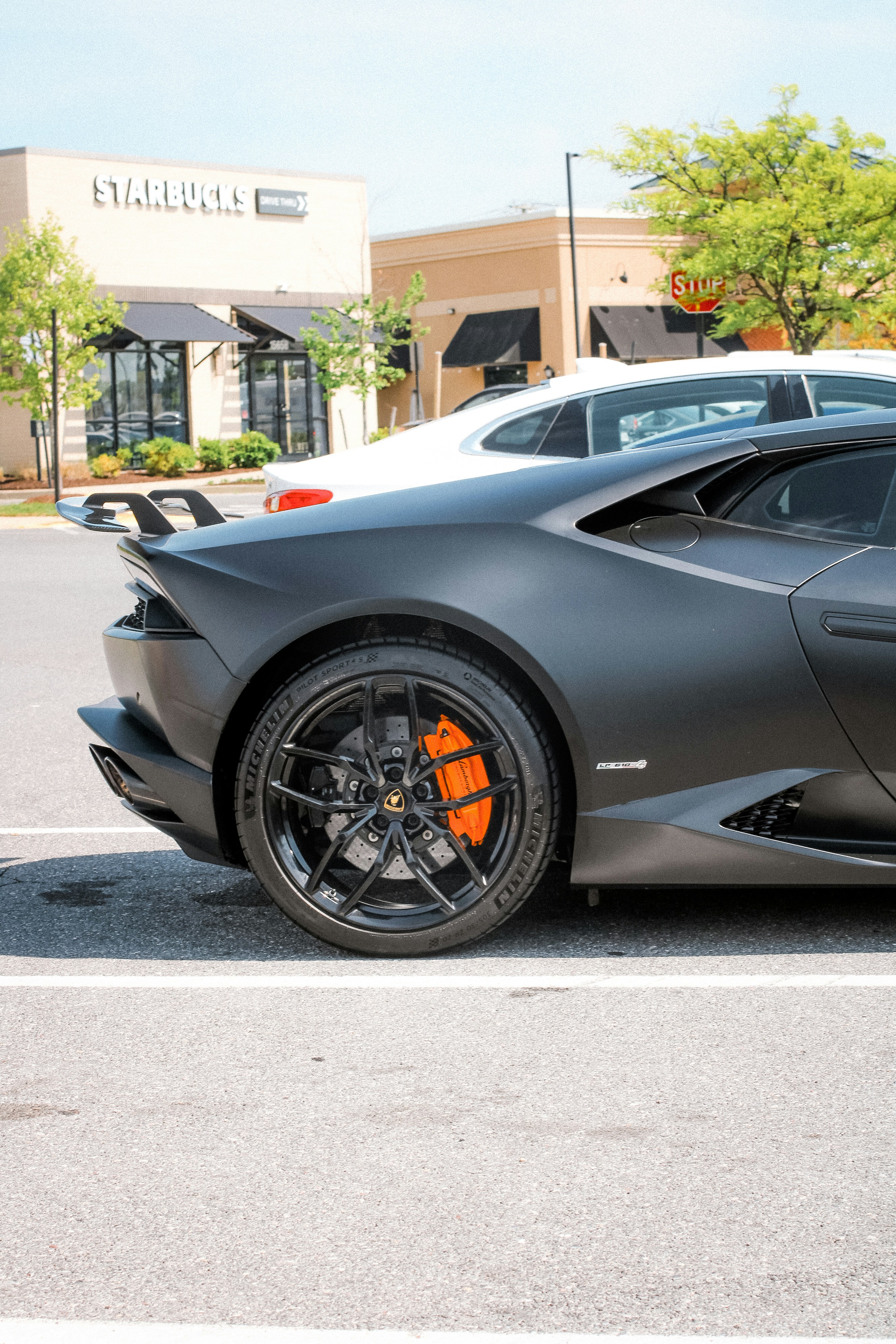 Matte black sports car with orange brake calipers