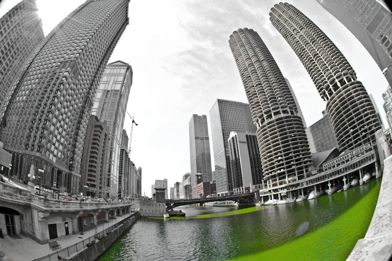 The Chicago River dyed bright green for St. Patrick's Day, with Marina City's corncob towers visible on the bank