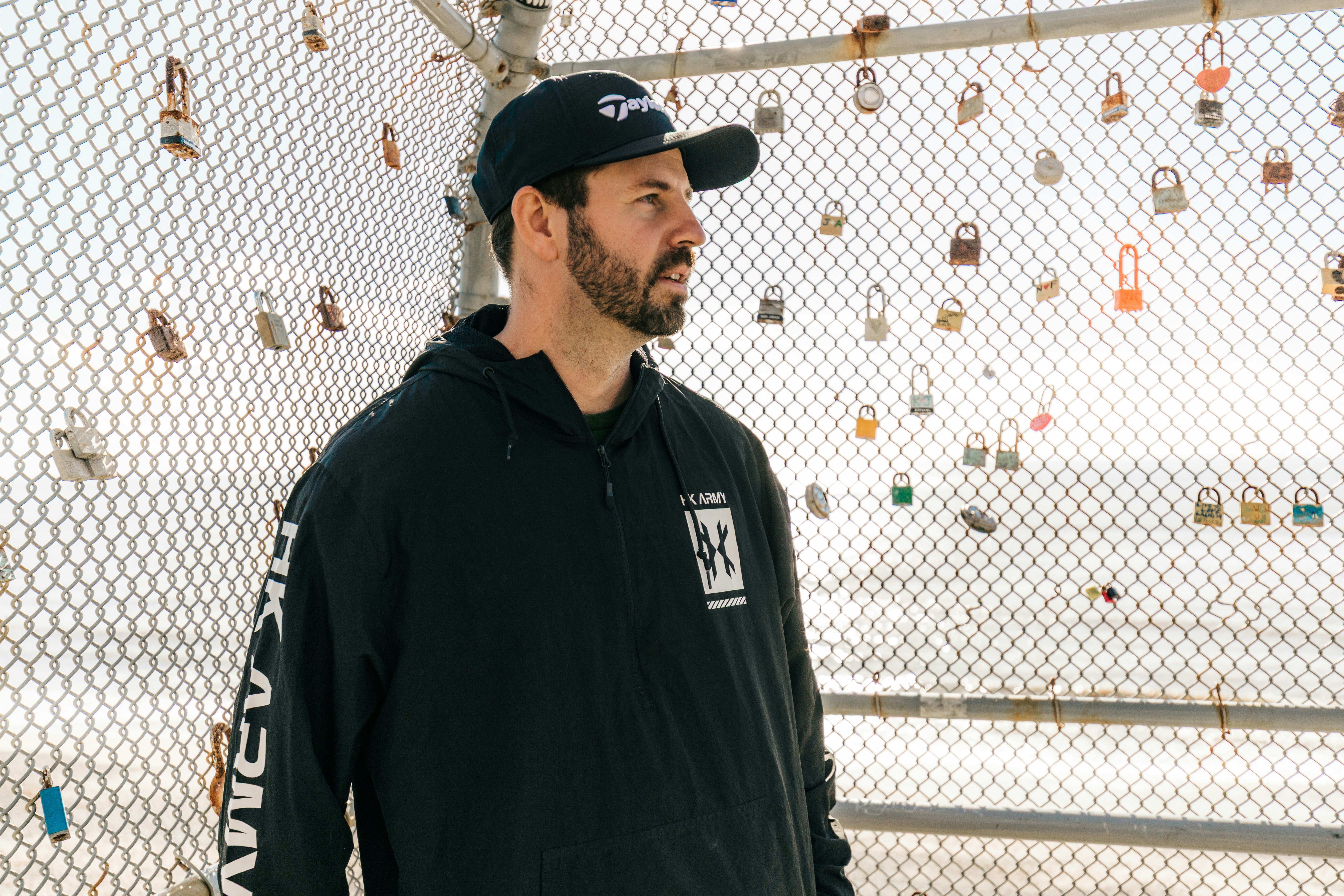 Homme portant un sweat à capuche noir et une casquette de baseball