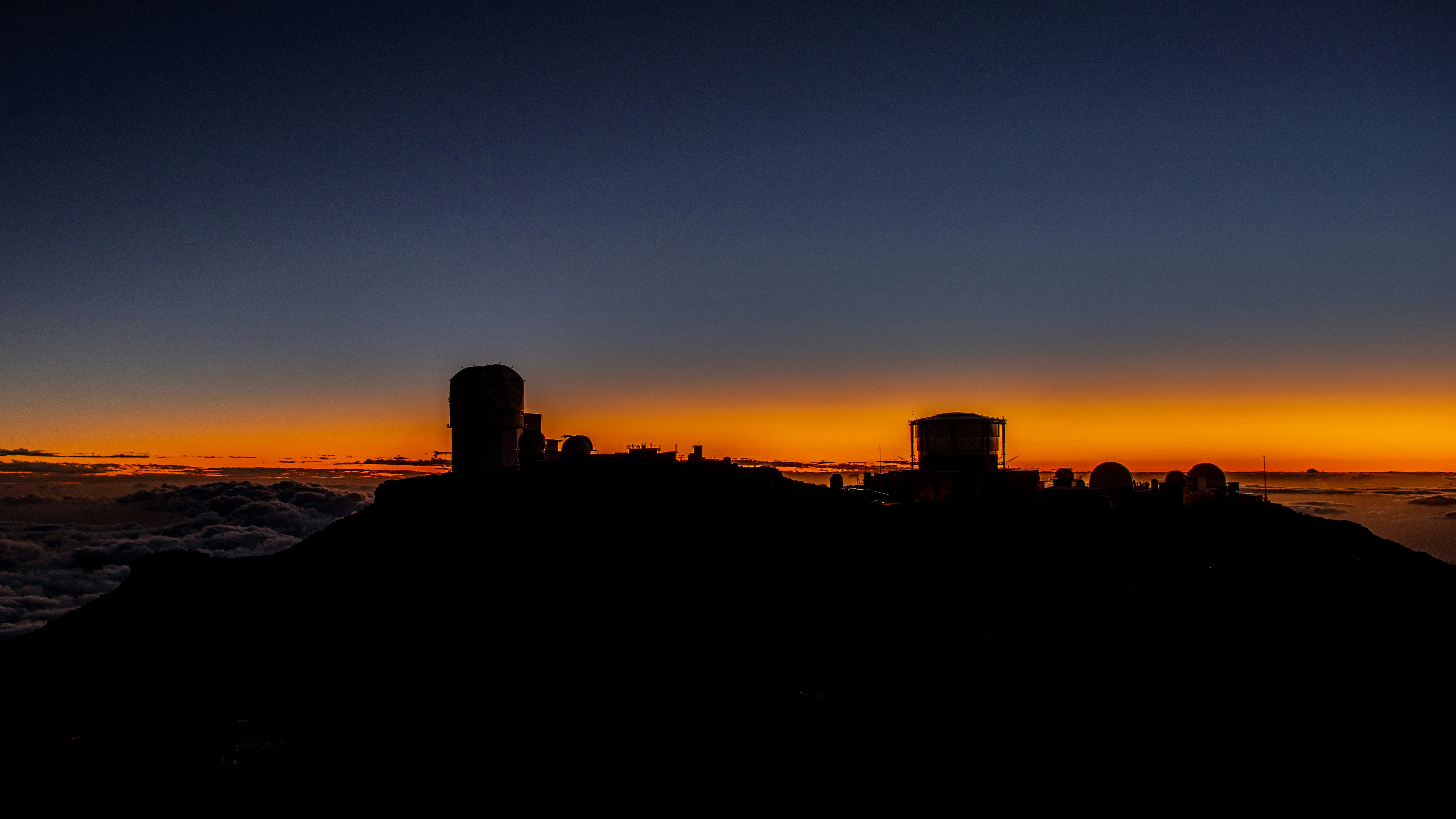 Des observatoires se découpant sur un ciel vibrant au coucher du soleil