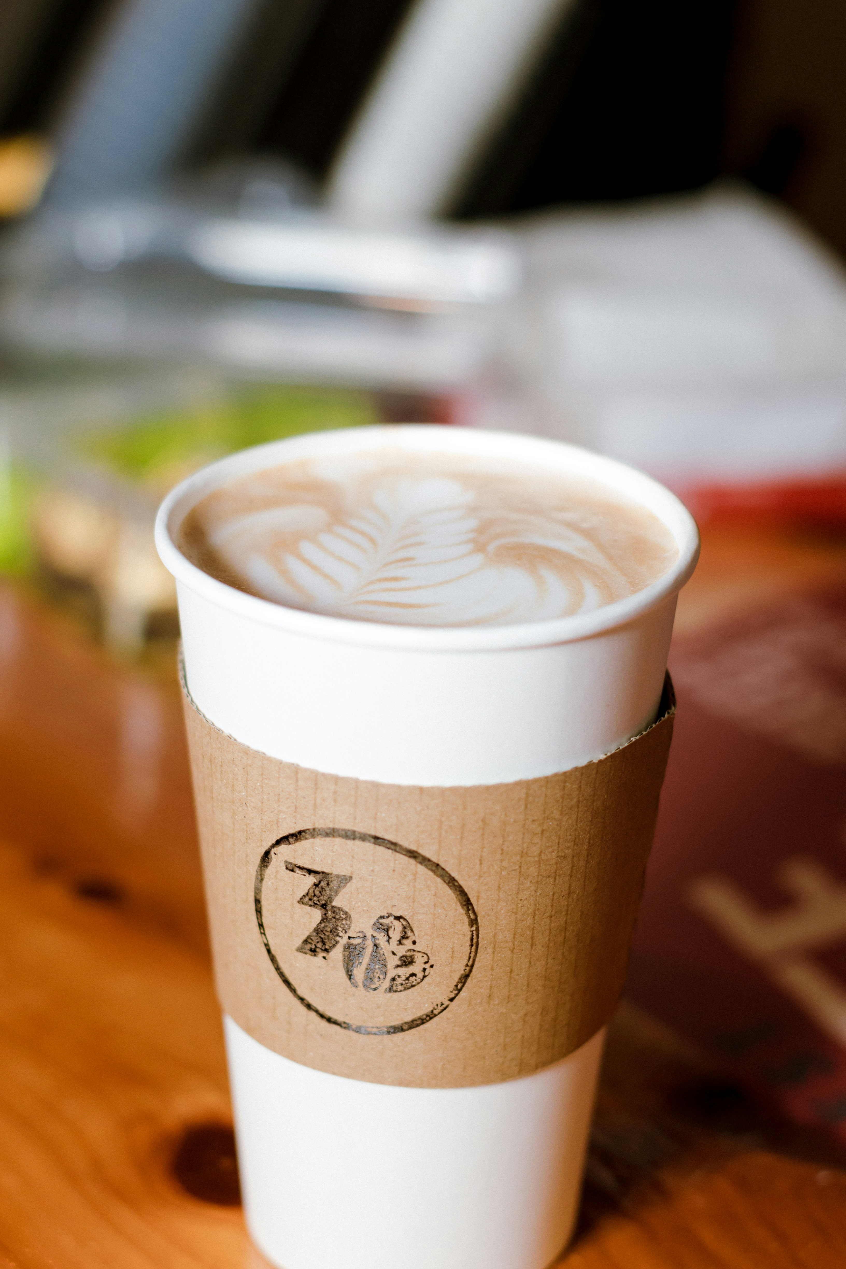 A latte with foam art in a to-go cup