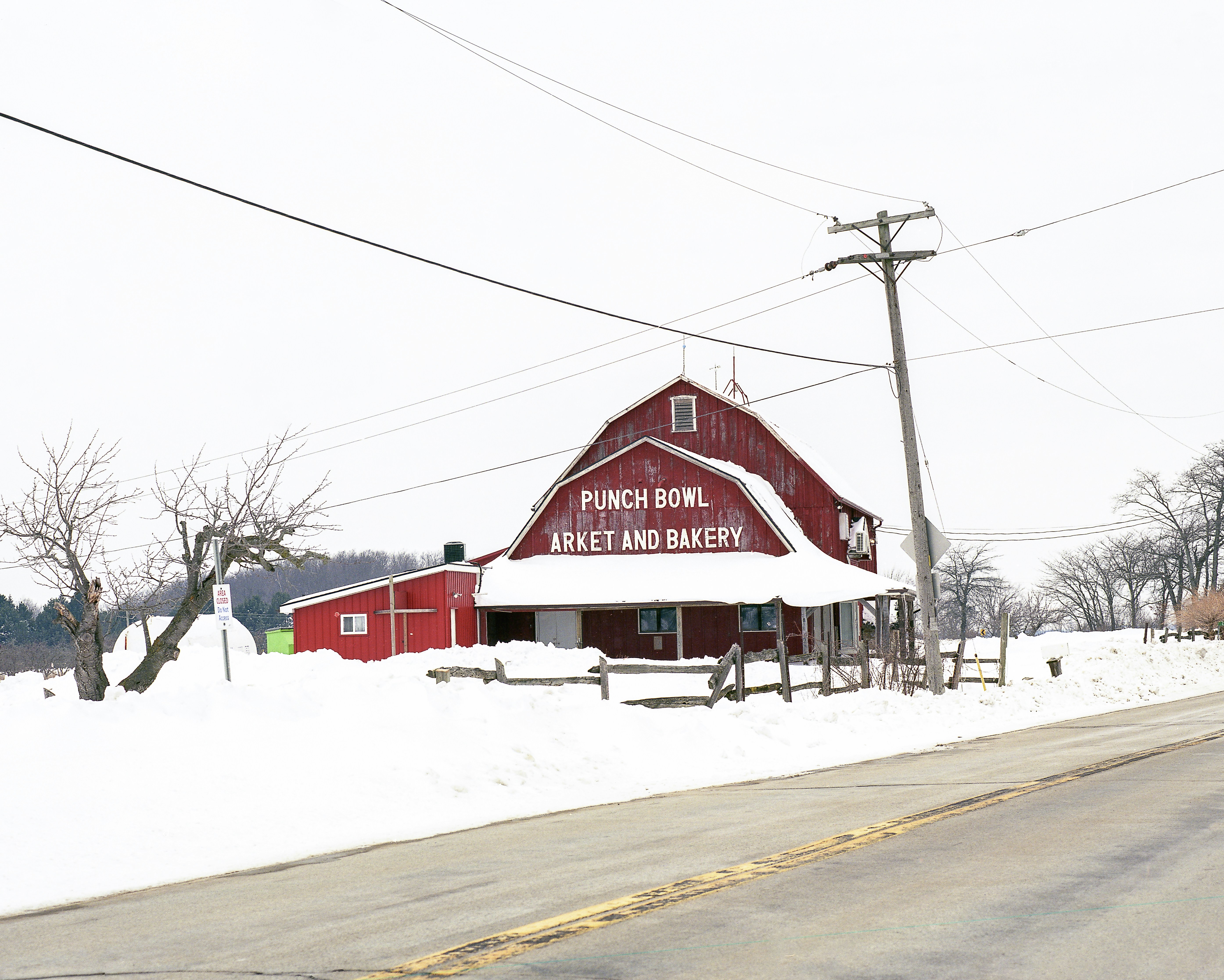 Red barn with punch bowl market and bakery in snow