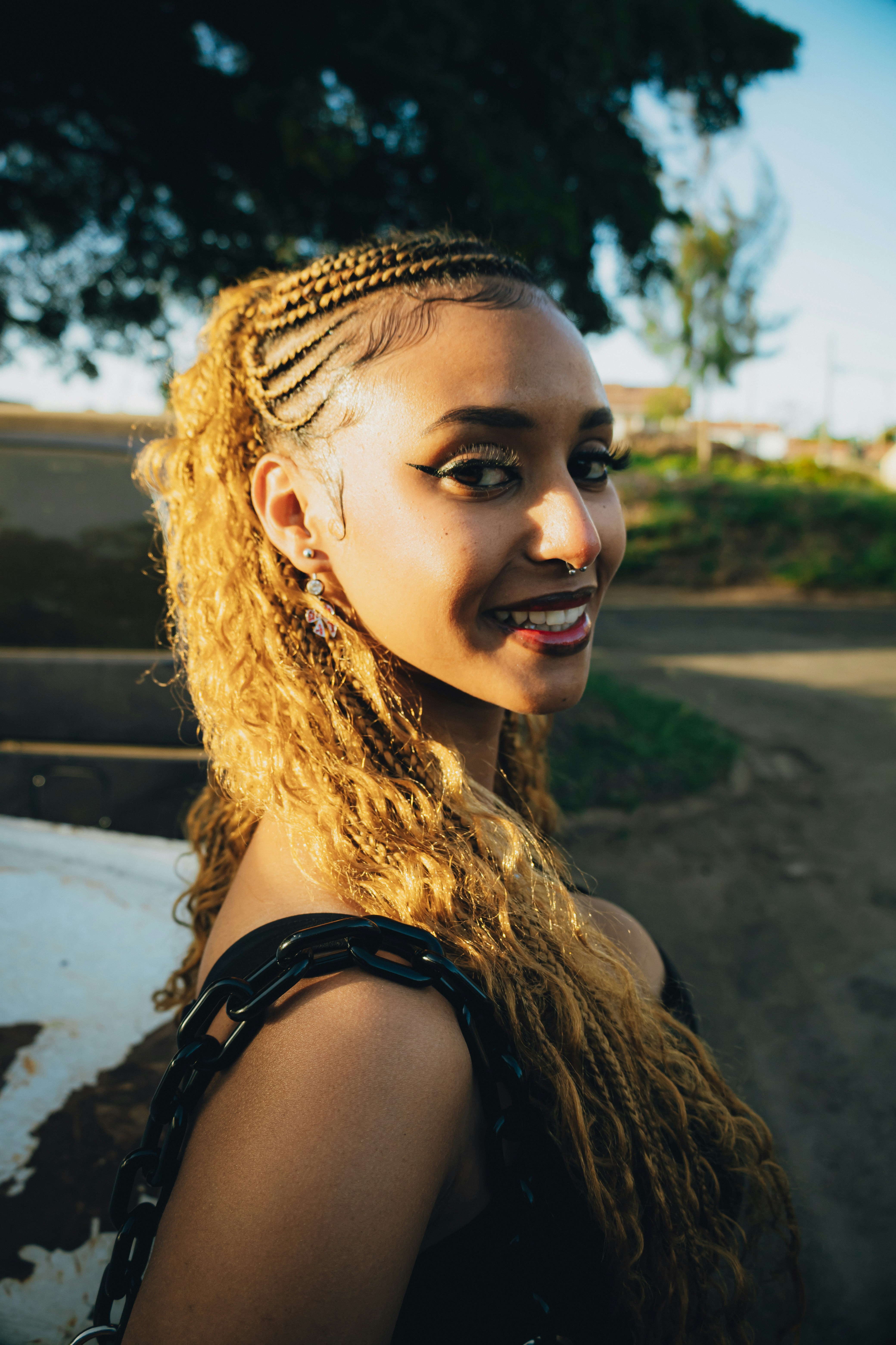 Young woman with blonde braids smiling outdoors
