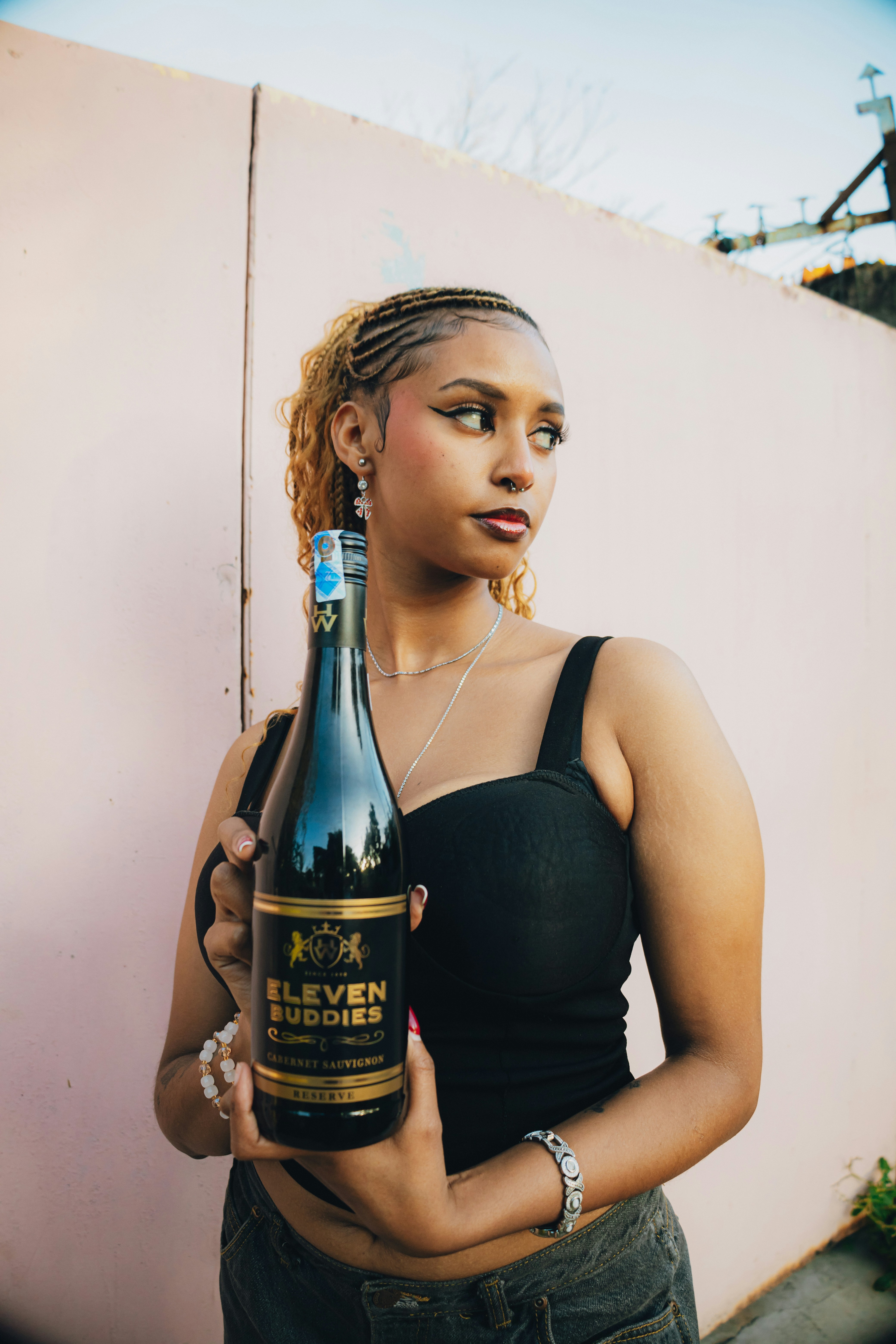 Young woman holding a bottle of eleven buddies wine.