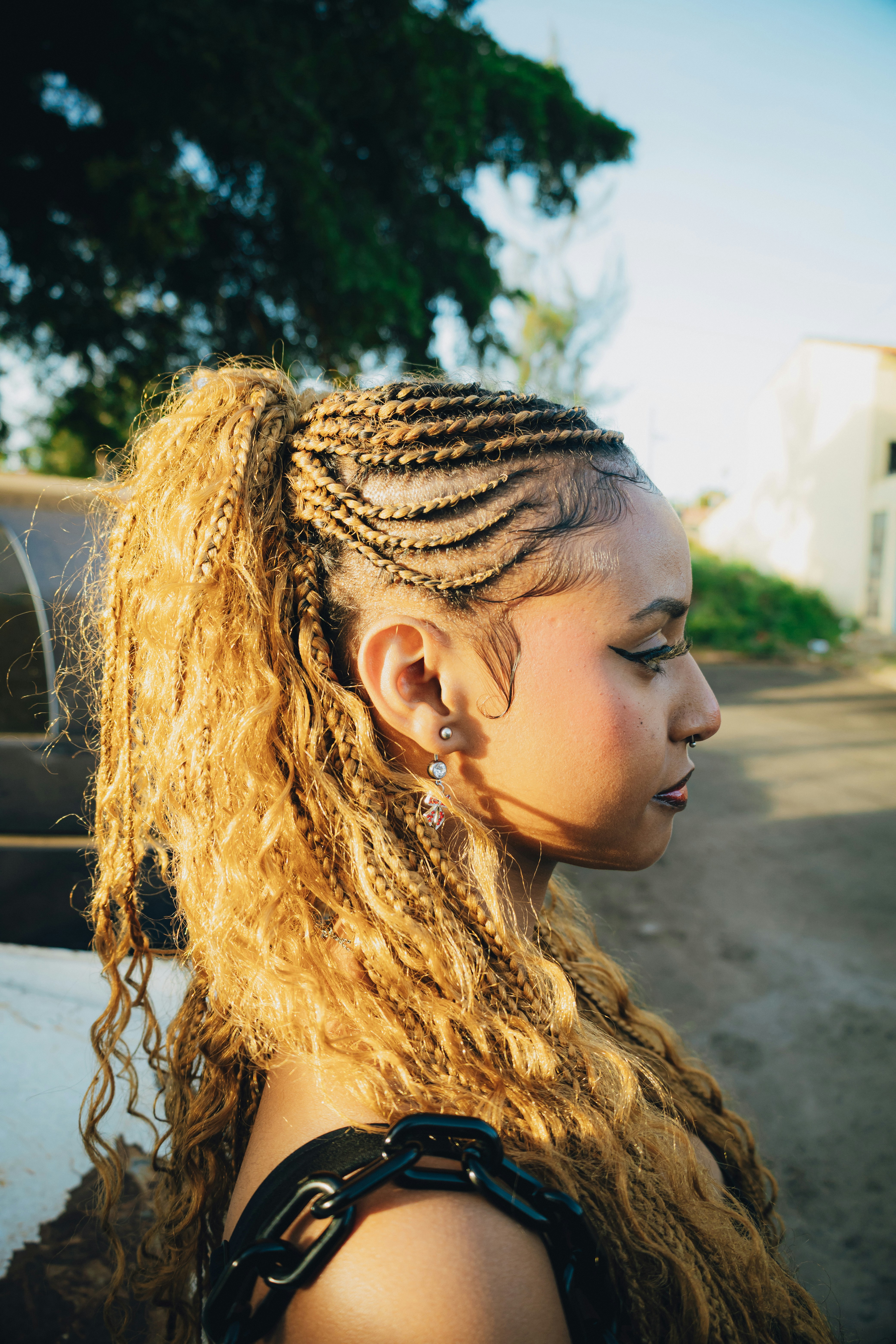Woman with blonde braided hair and ponytail outdoors
