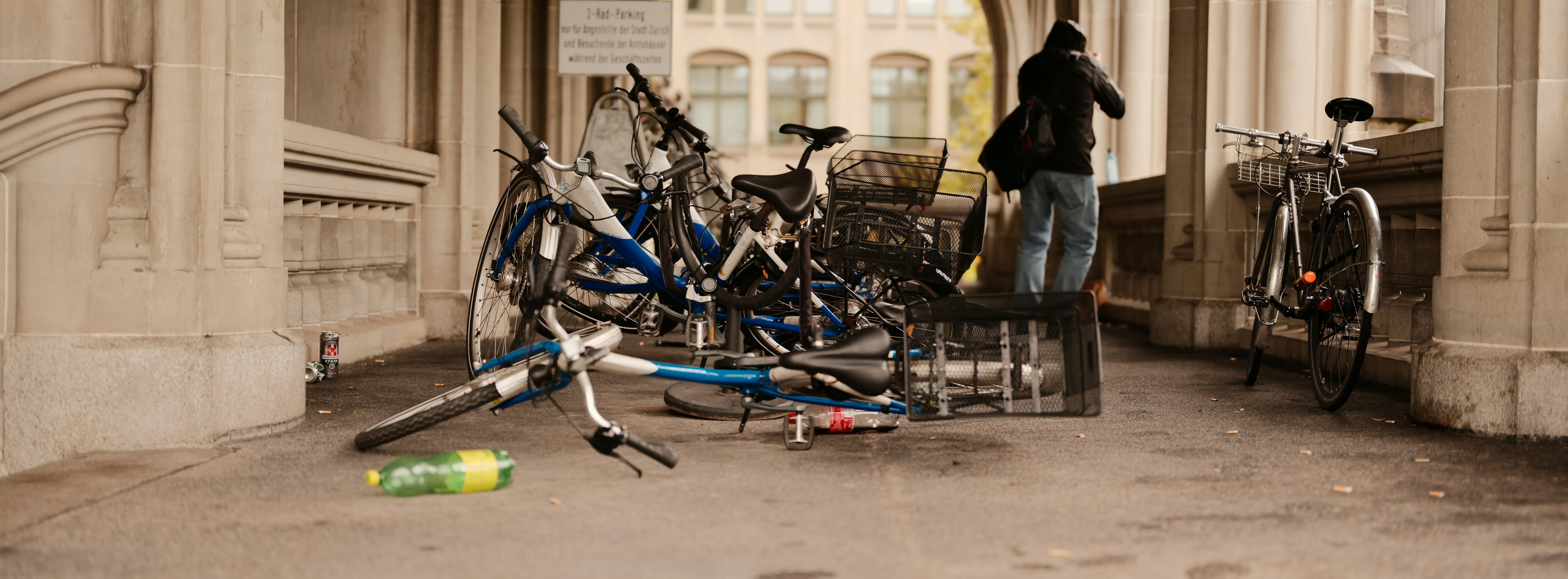 A person stands near a rack of bicycles.