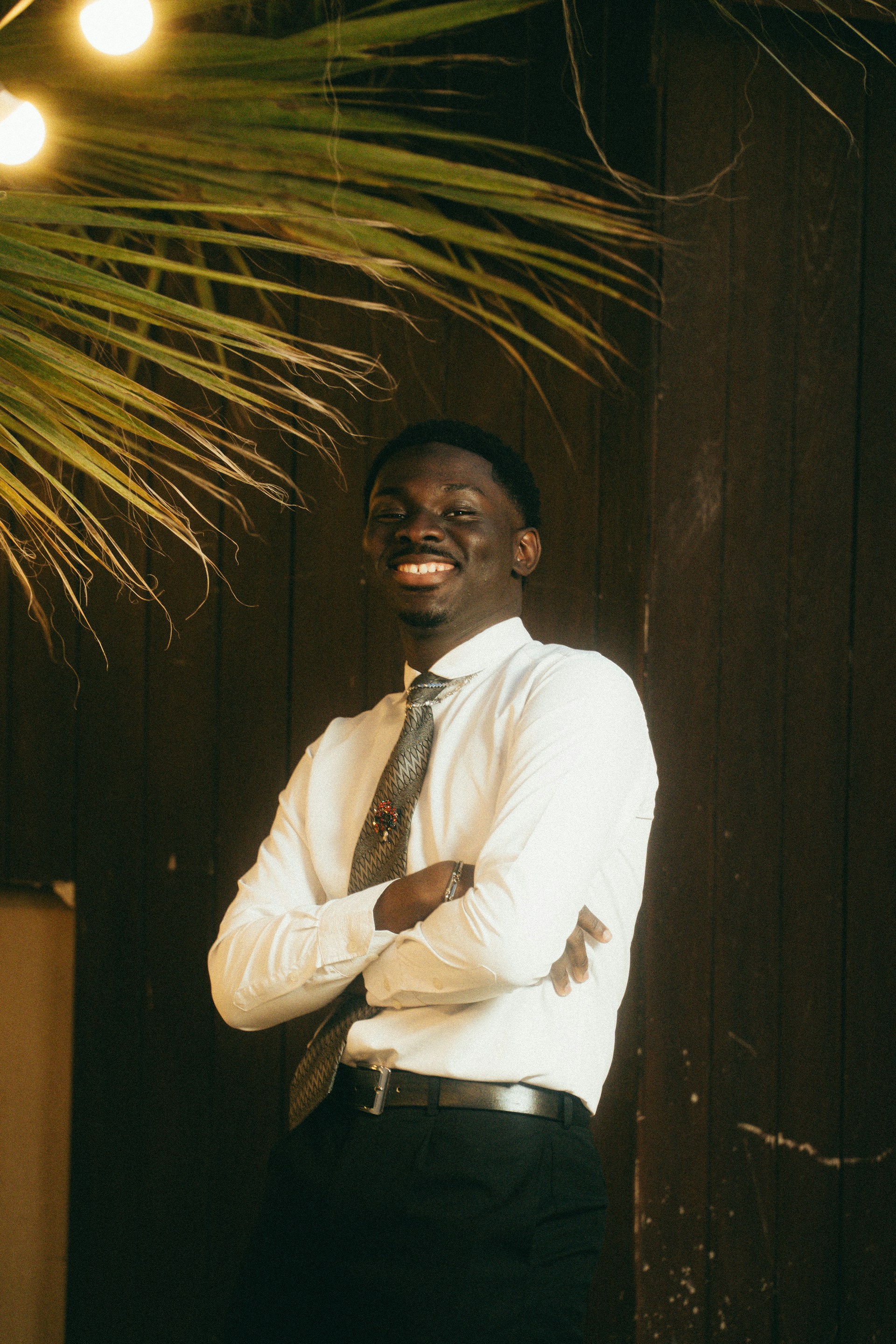 A smiling black man in a white shirt and tie.