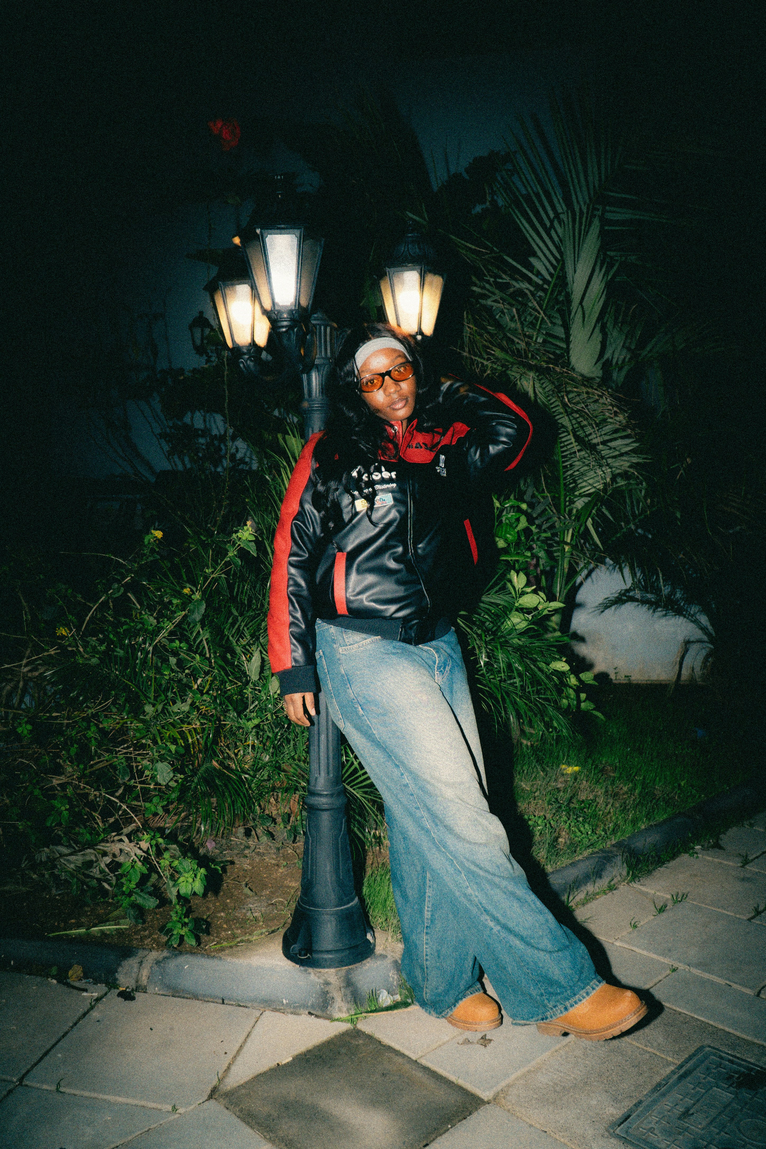 Una persona se apoya en una farola por la noche.