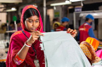 Woman inspecting fabric in a factory setting.