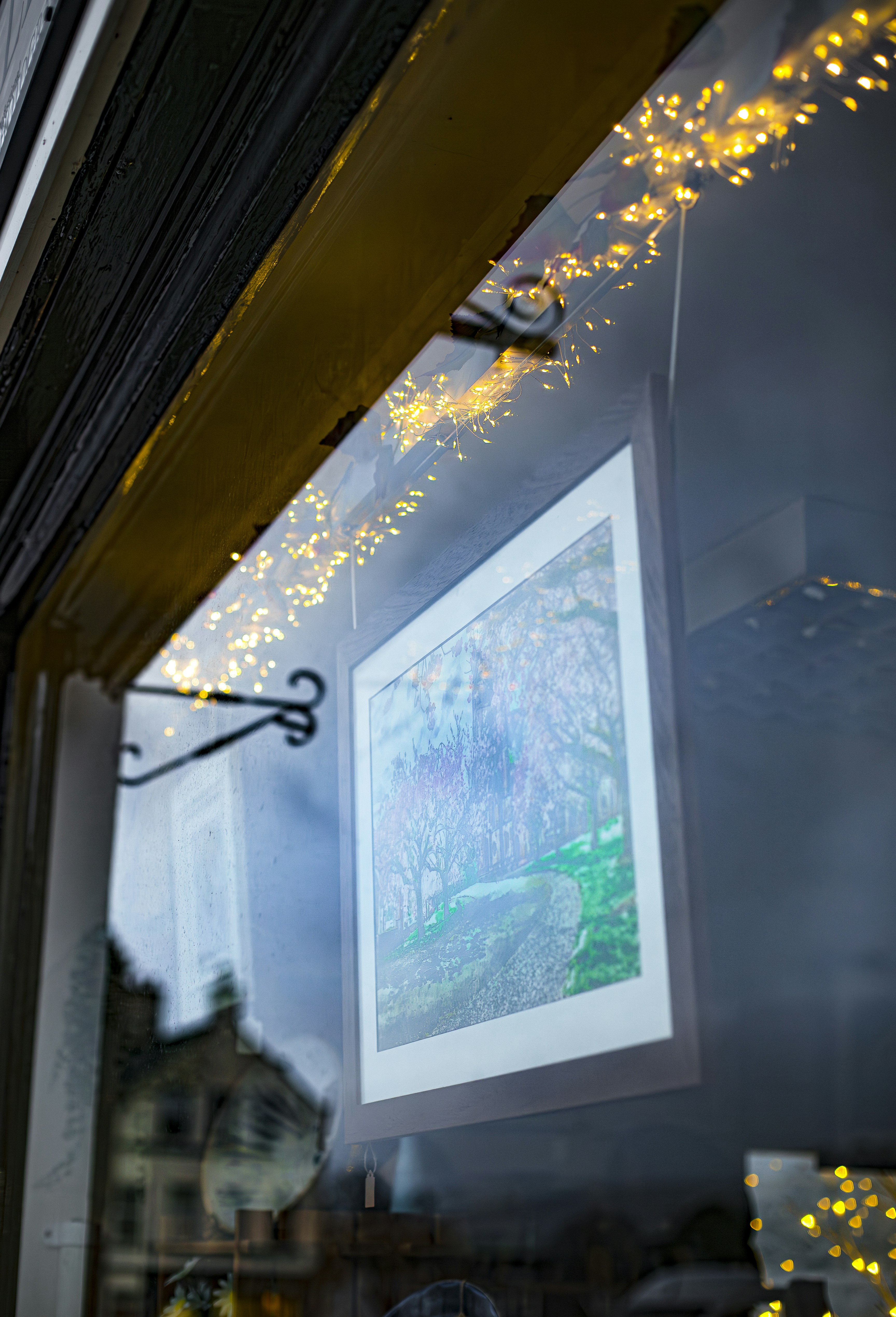 Kunstwerke, die in einem Fenster mit Lichterketten ausgestellt sind
