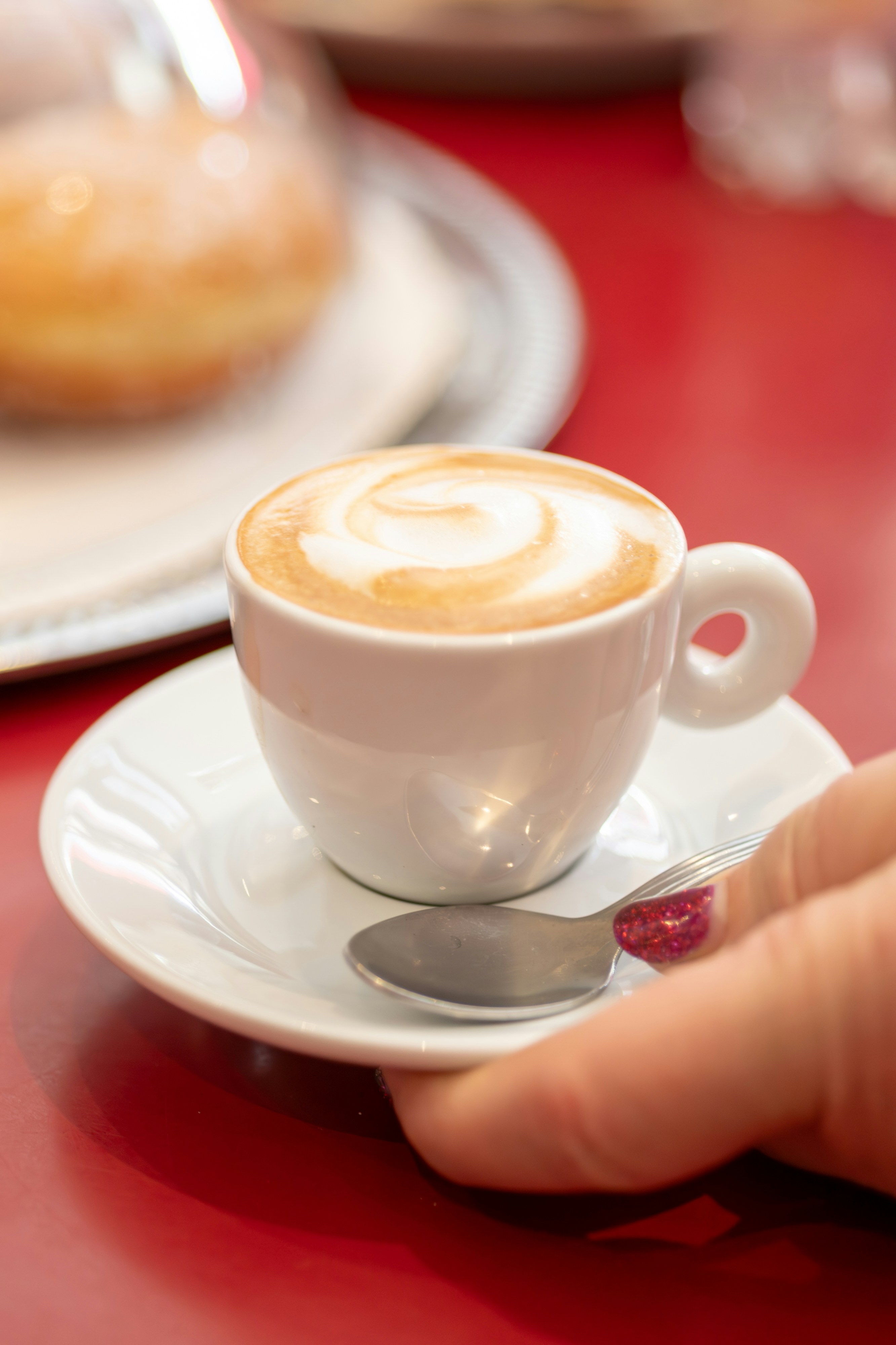 Eine Hand hält eine Untertasse mit einer Tasse Kaffee