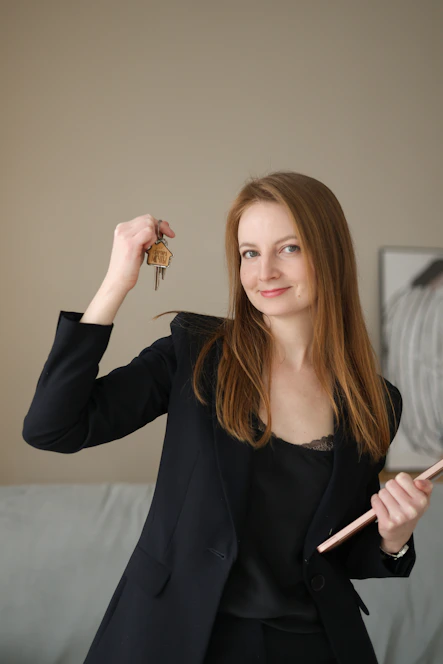 Woman in suit holding keys and a clipboard