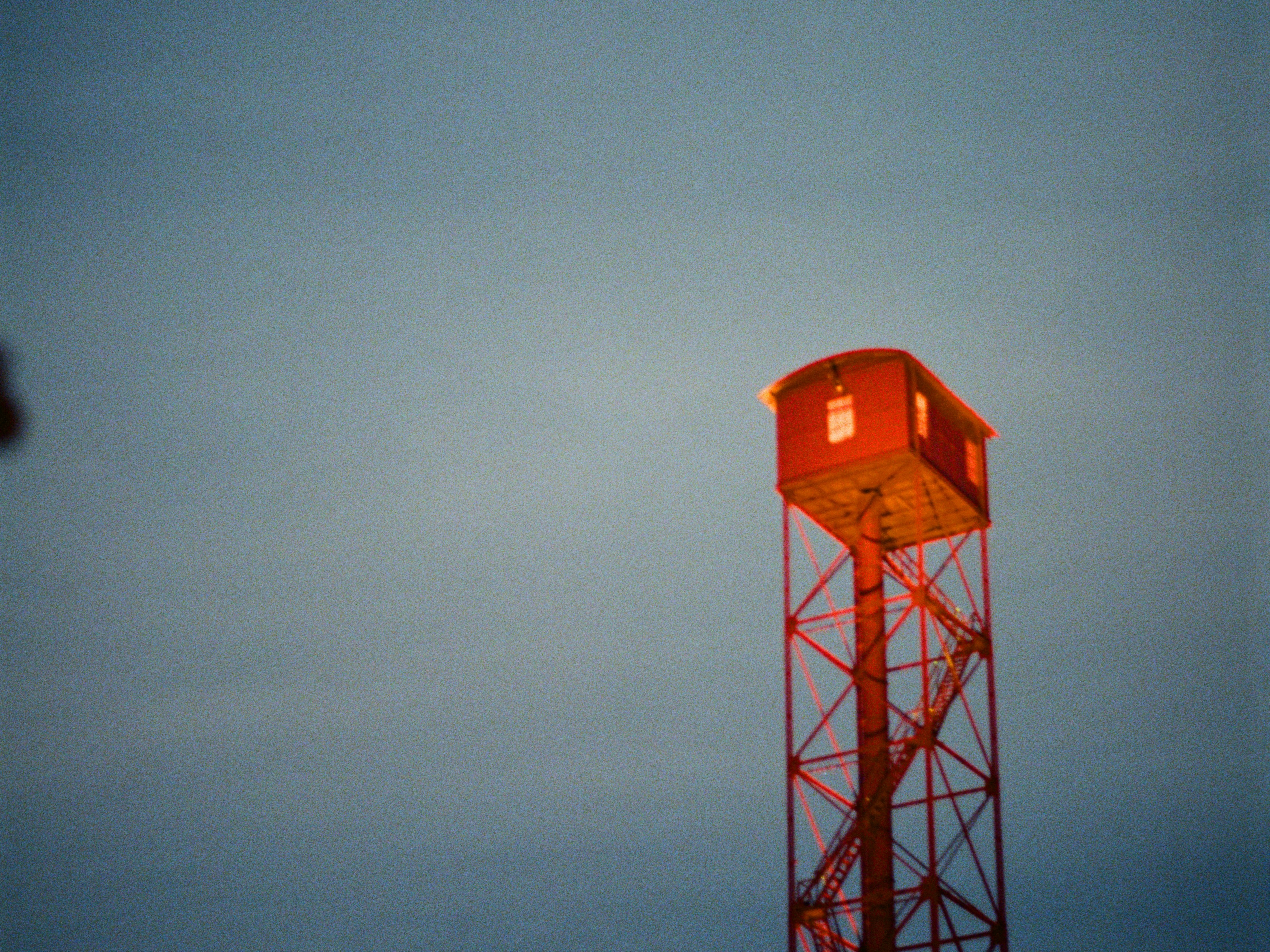 A small red structure atop a tall metal tower