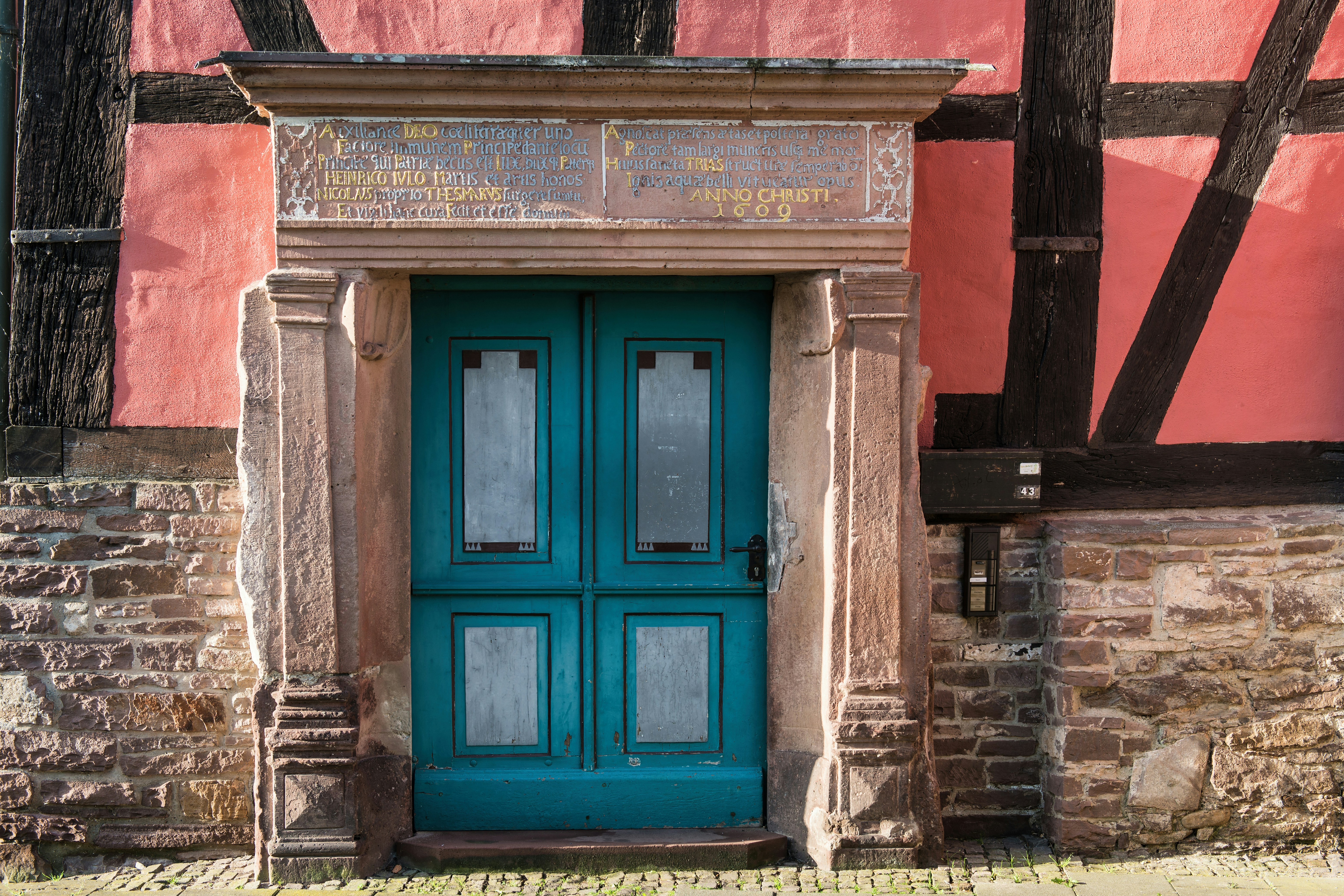 A teal double door with ornate stone frame