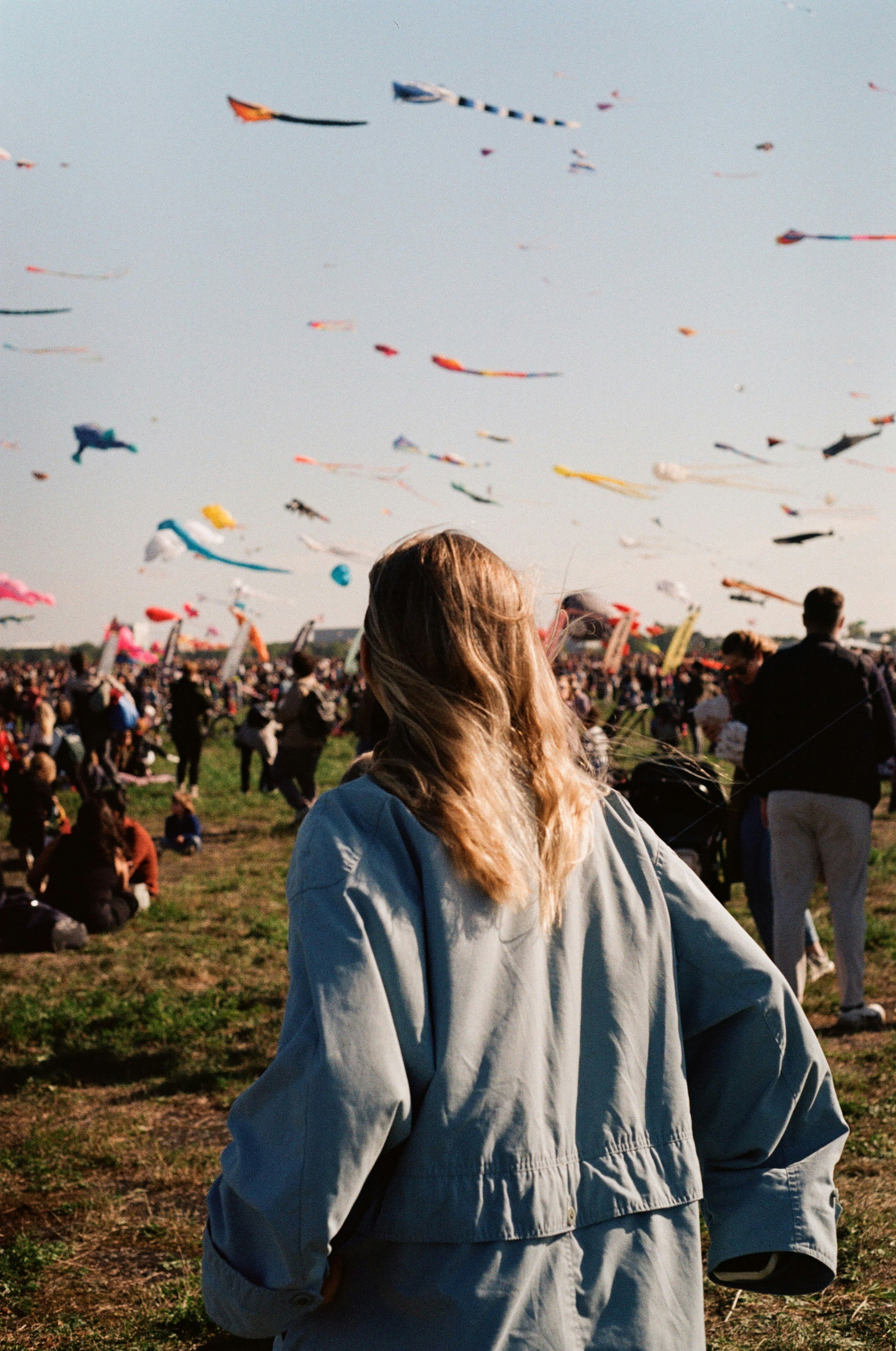 Photo of Woman watches many kites flying in the sky by Oksana Demenko