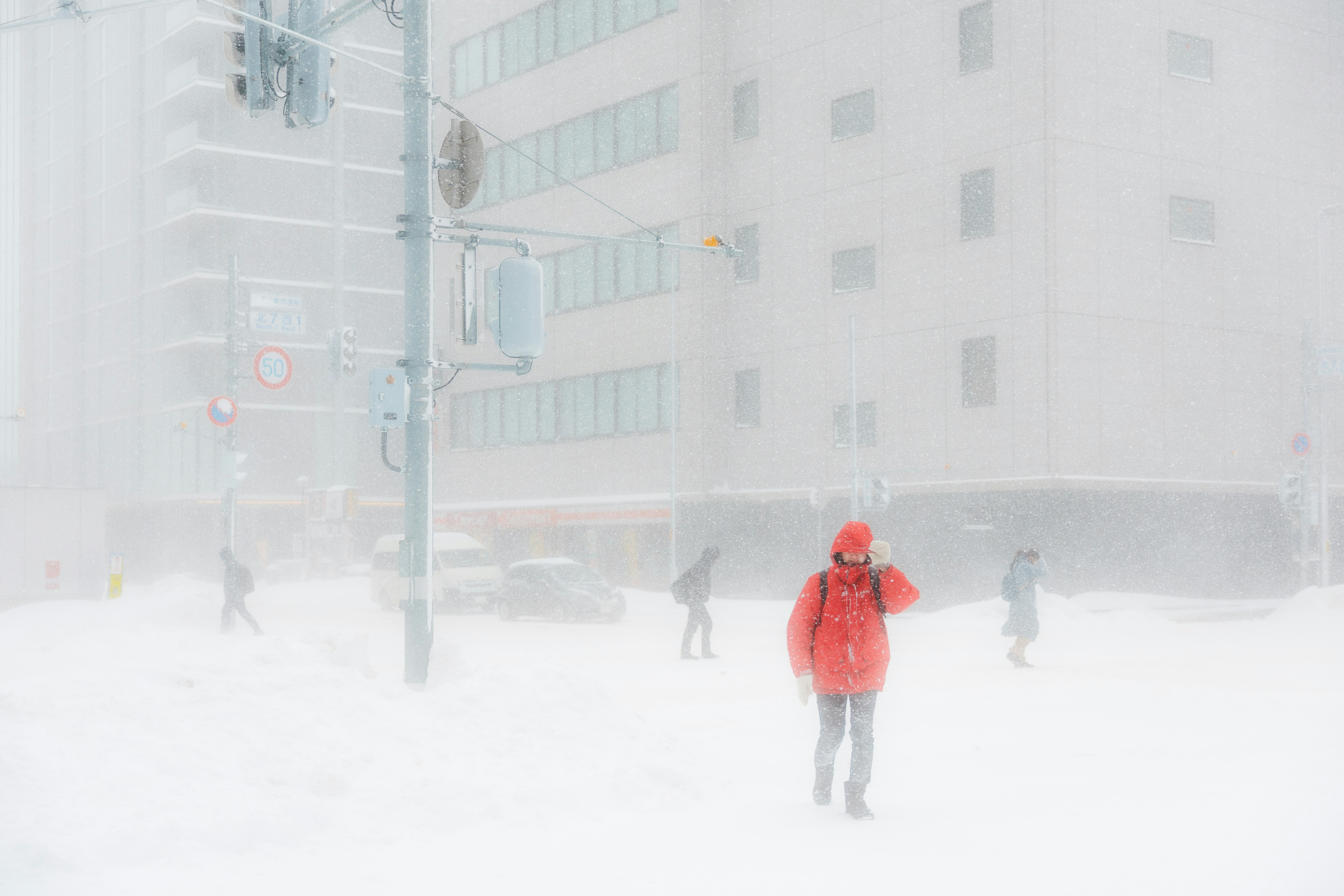 People walk through a blizzard in a city
