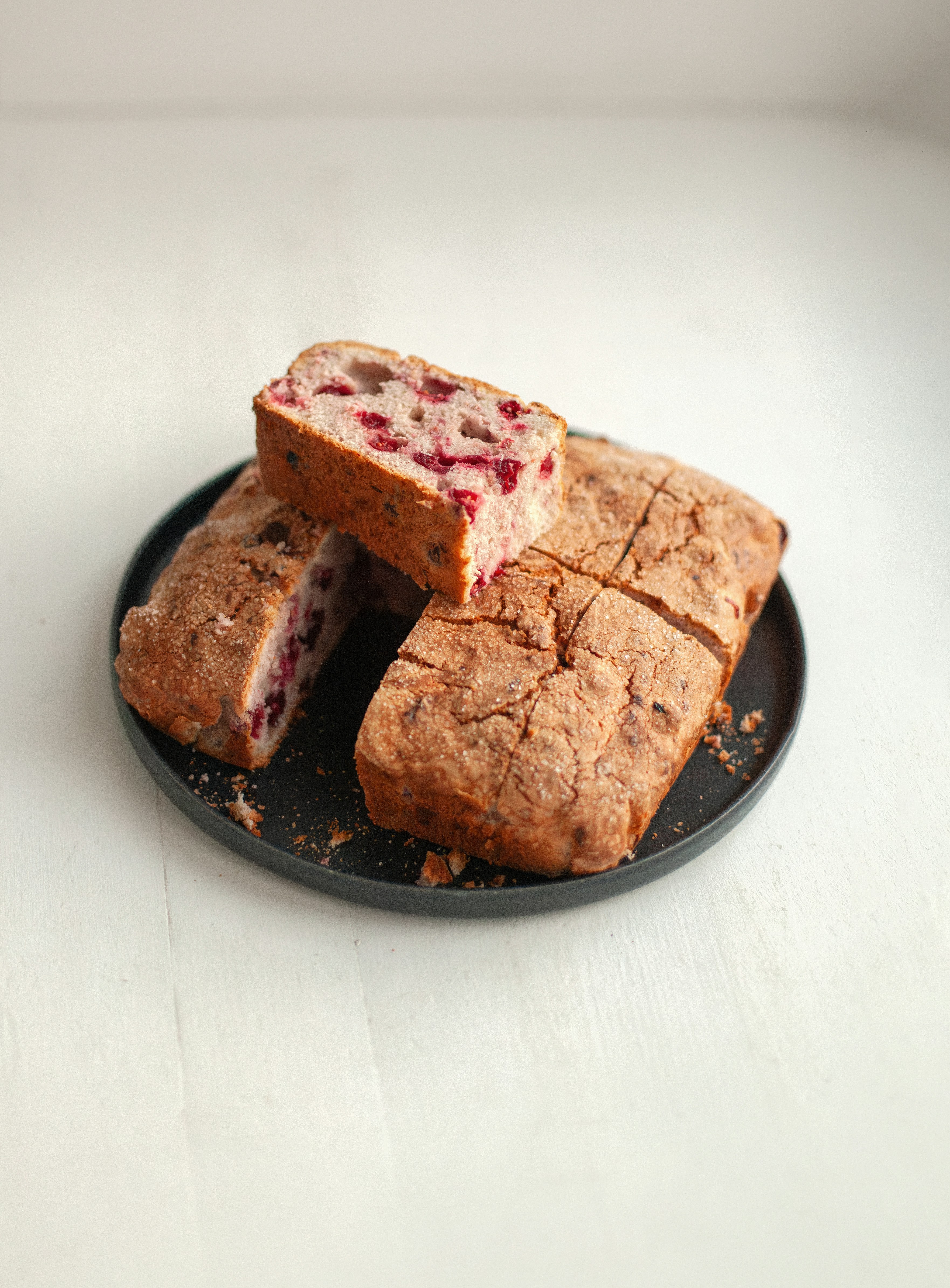A loaf of bread with berries on a plate