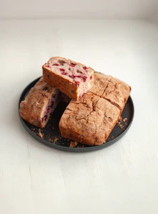 A loaf of bread with berries on a plate